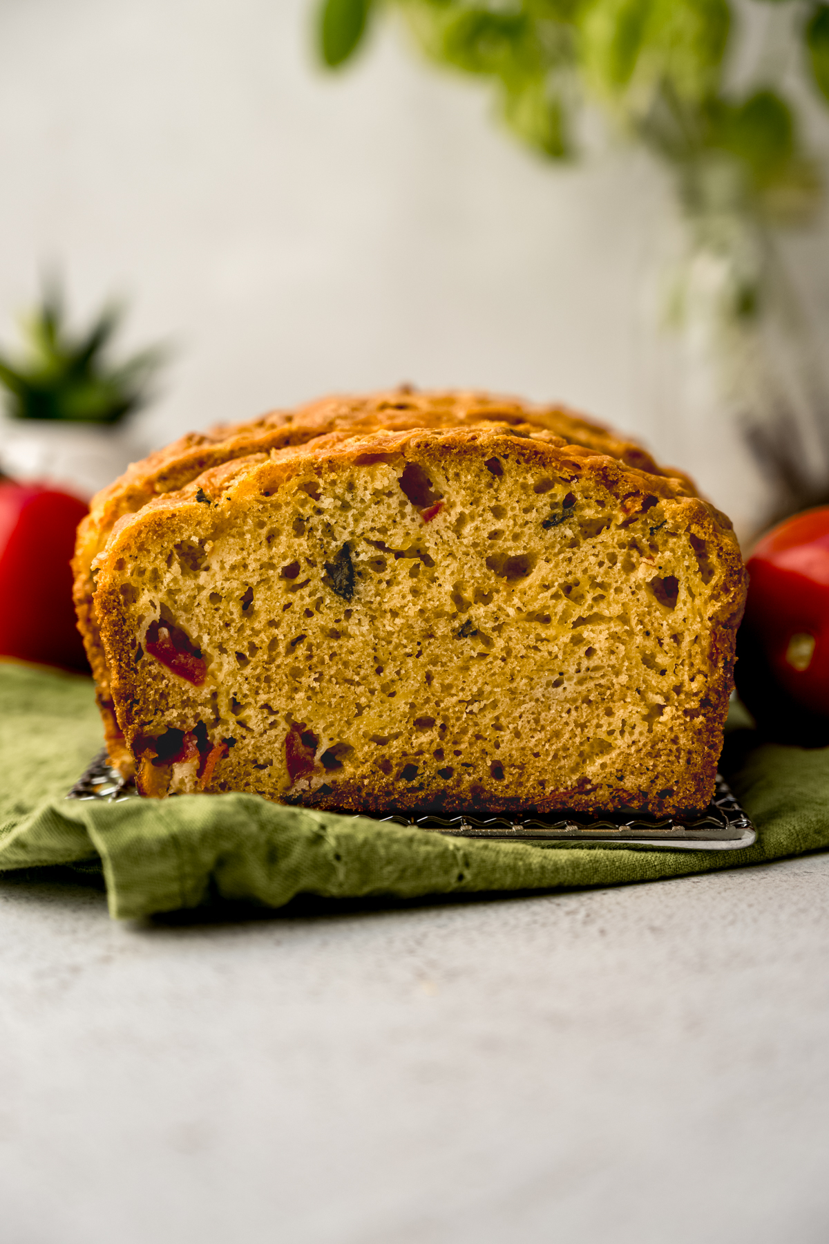 Sliced tomato basil bread on a surface.