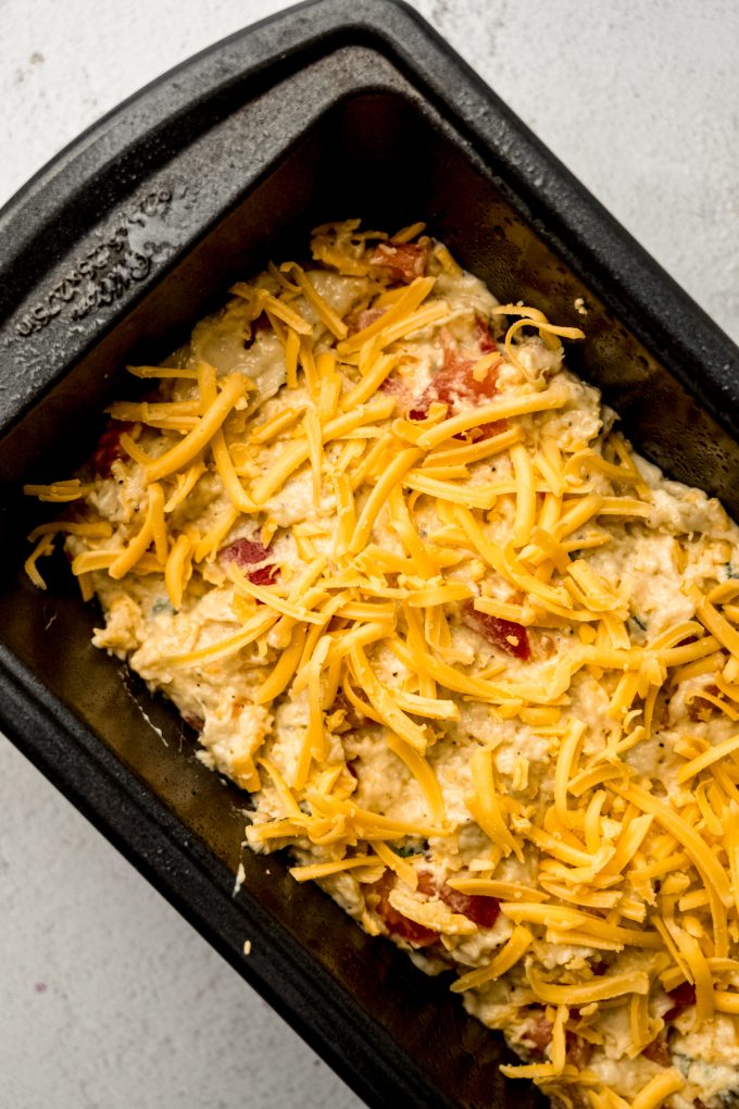 Aerial photo of tomato basil bread in a loaf pan before getting baked.
