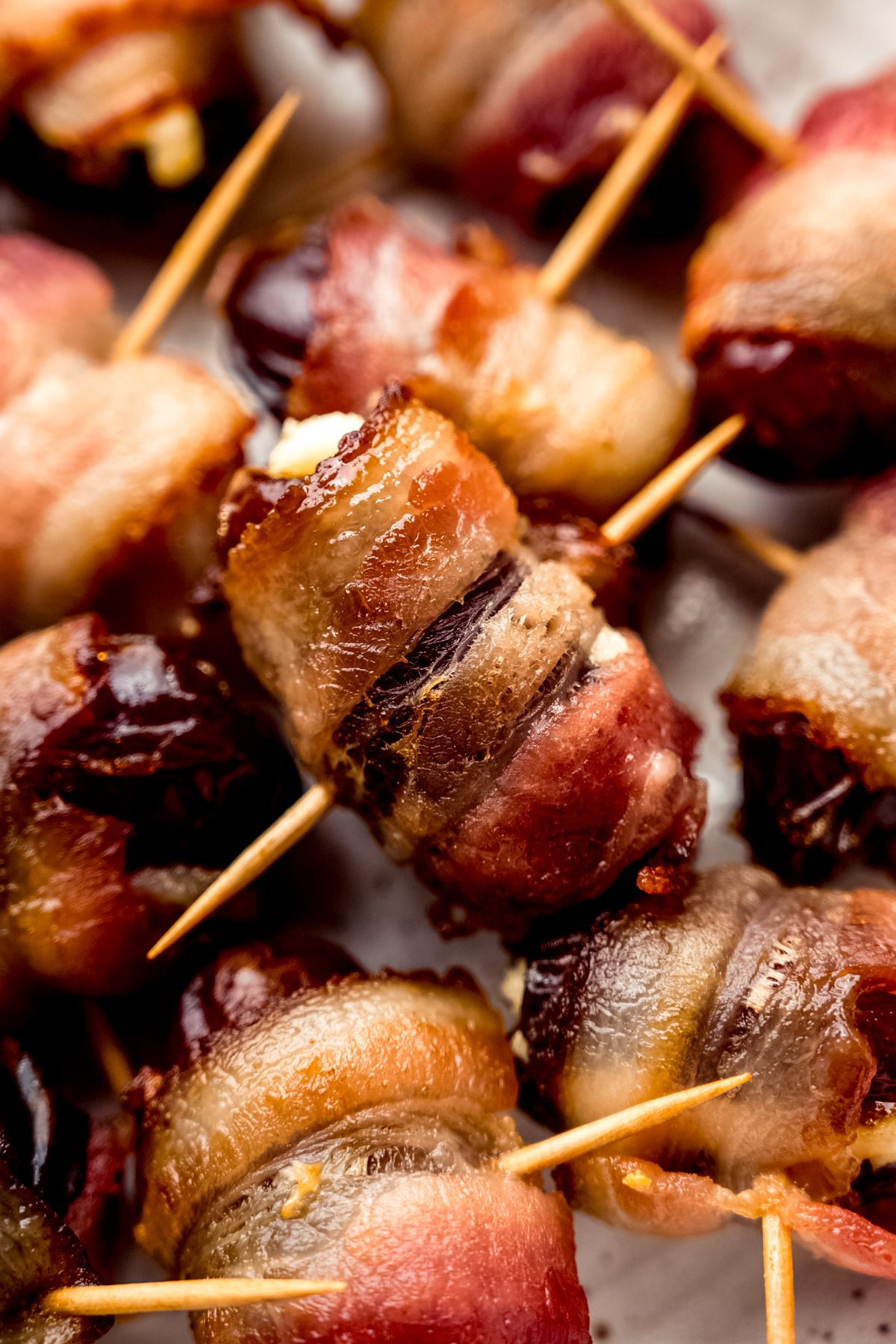 A closeup photo of a bacon wrapped date stuffed with goat cheese.