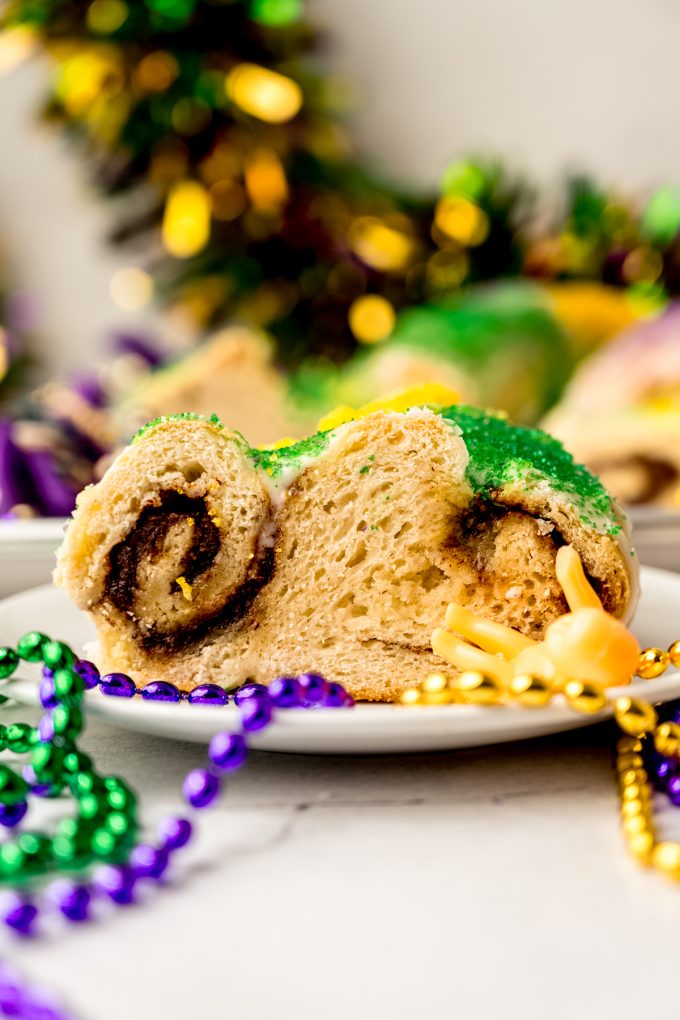 A slice of Mardi Gras king cake on a plate.