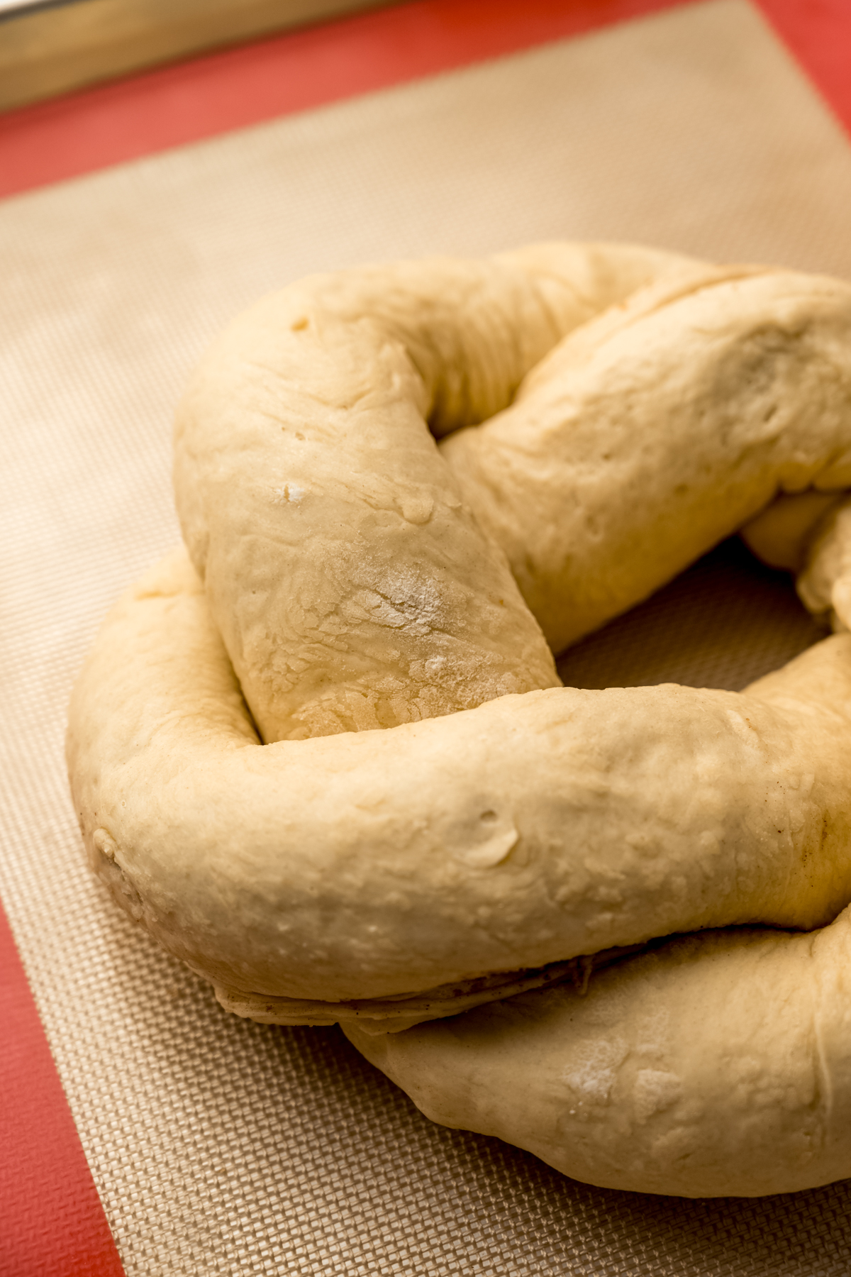 A closeup photo of a shaped Mardi Gras king cake.
