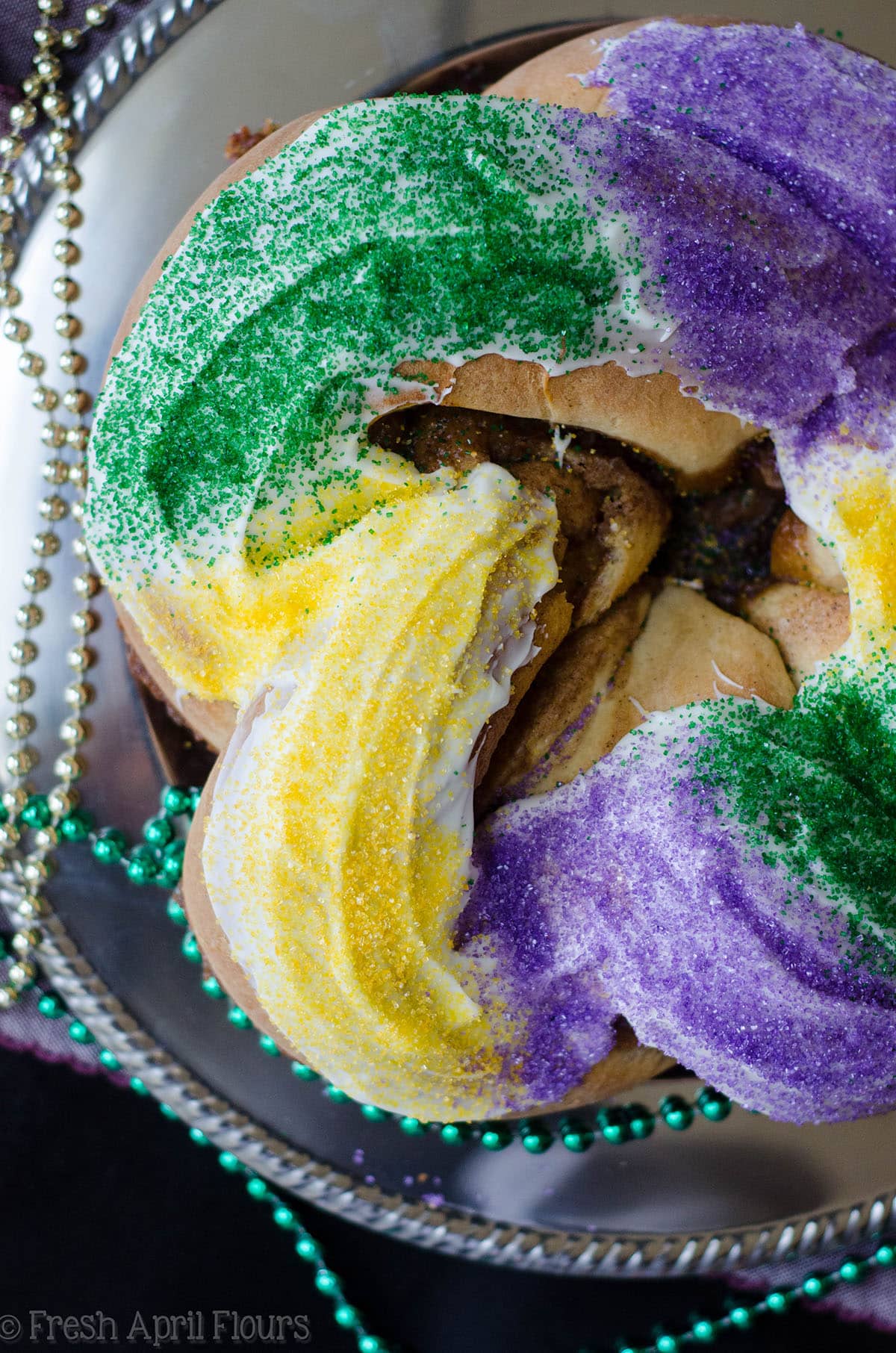 aerial photo of mardi gras king cake with beads around it
