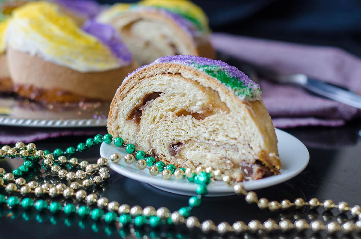 mardi gras cake on a plate with beads around it