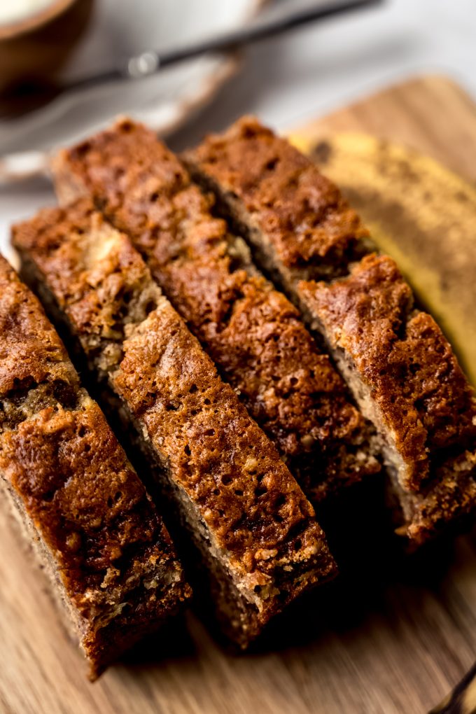 Slices of banana nut bread on a cutting board.