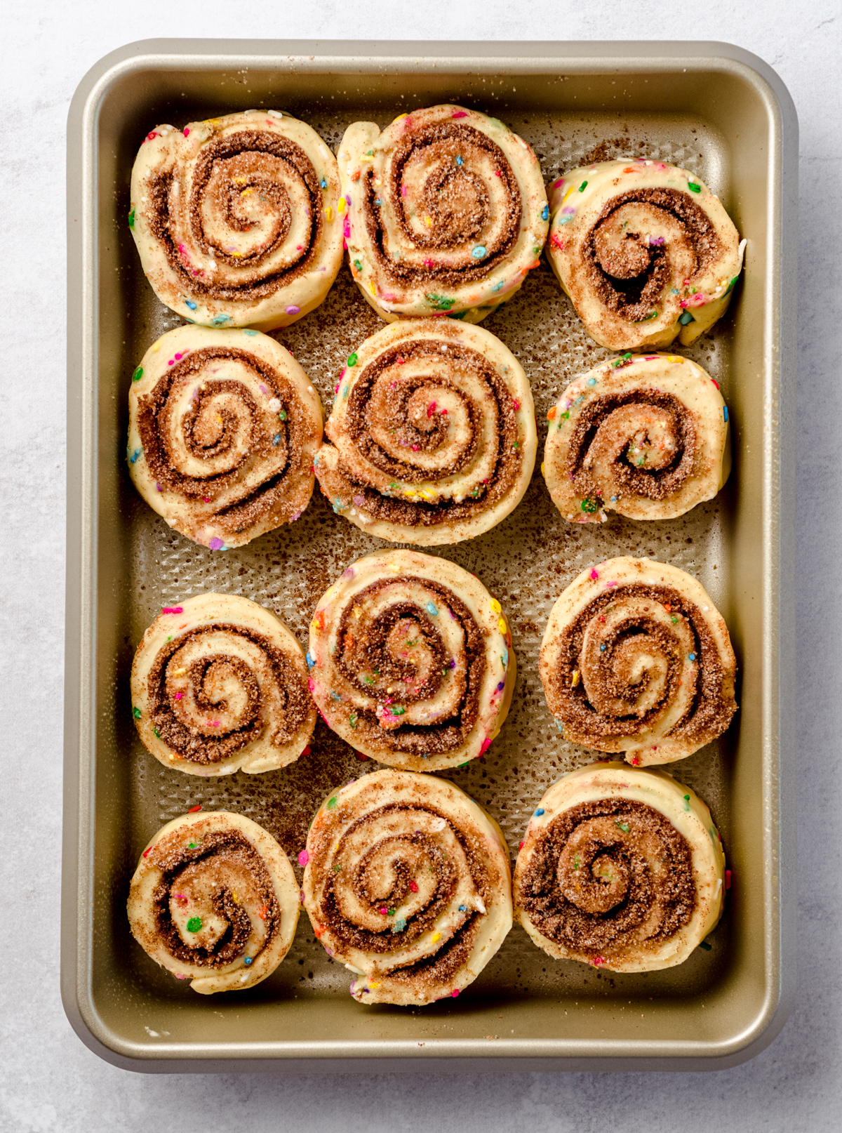 Aerial photo of funfetti cinnamon rolls in a baking pan before rising.
