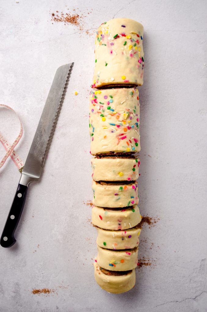 Sliced funfetti cinnamon roll dough from an overhead perspective.