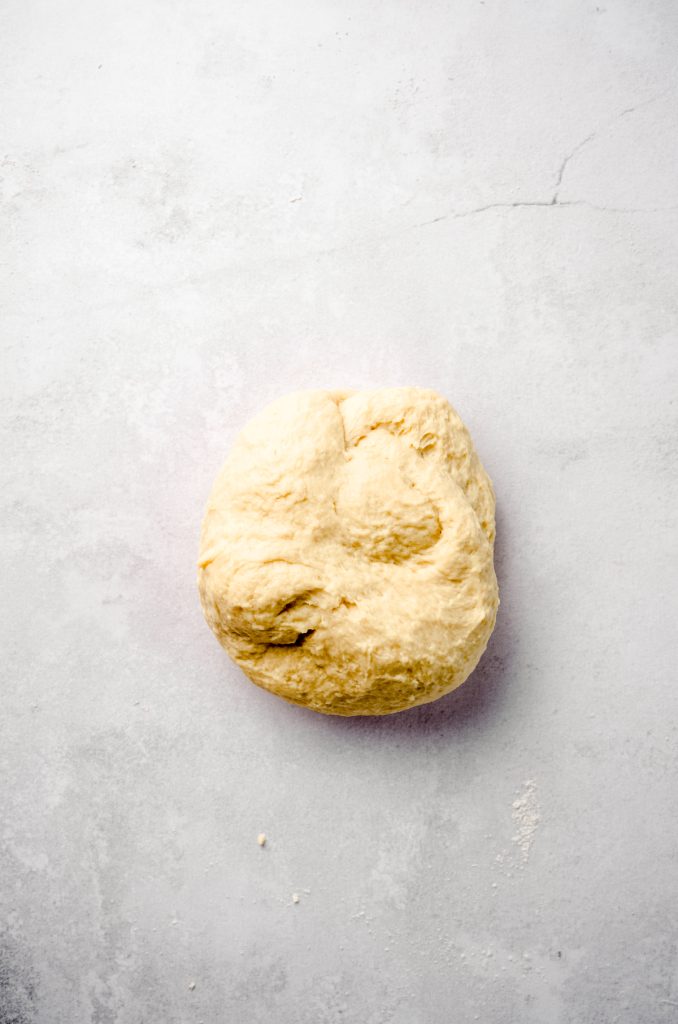 A ball of cinnamon roll dough before rolling out into a rectangle.