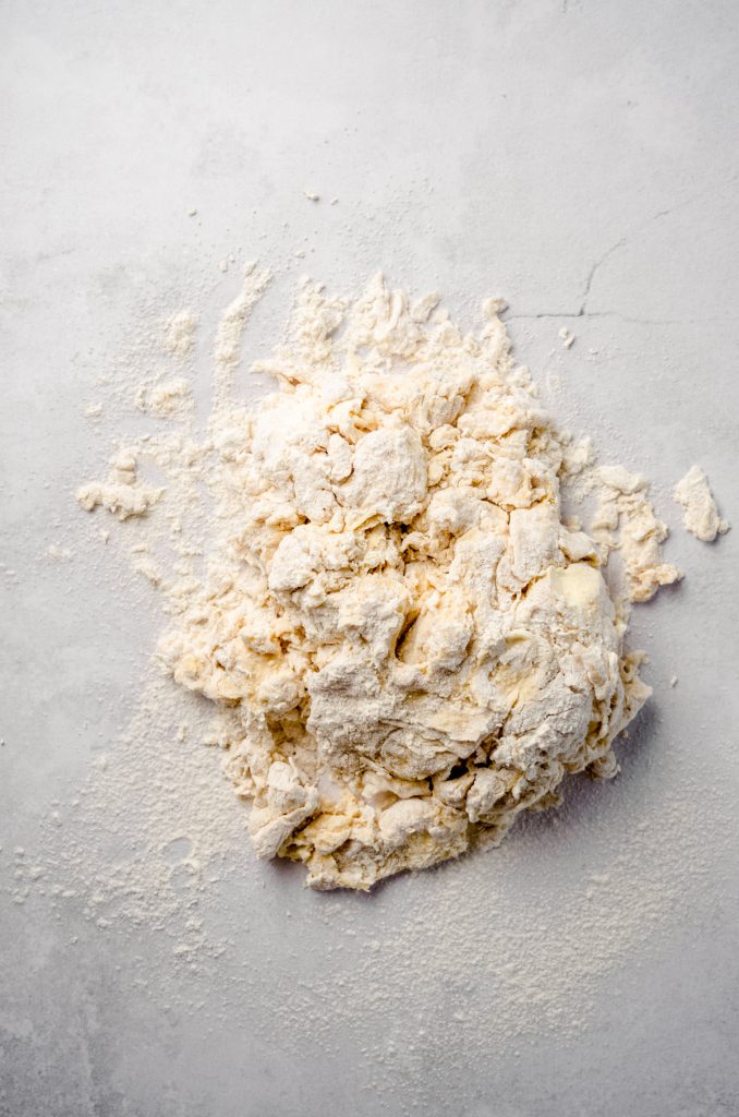Shaggy cinnamon roll dough on a surface.