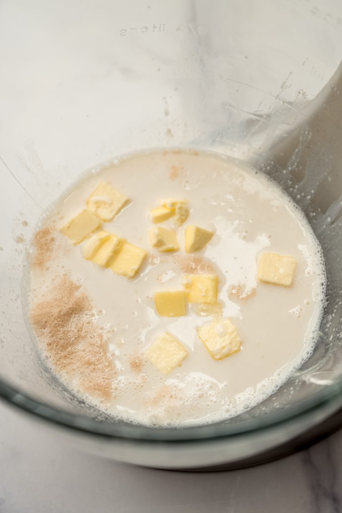 Liquid ingredients and cubed butter in the bottom of a bowl to make yeast bread.