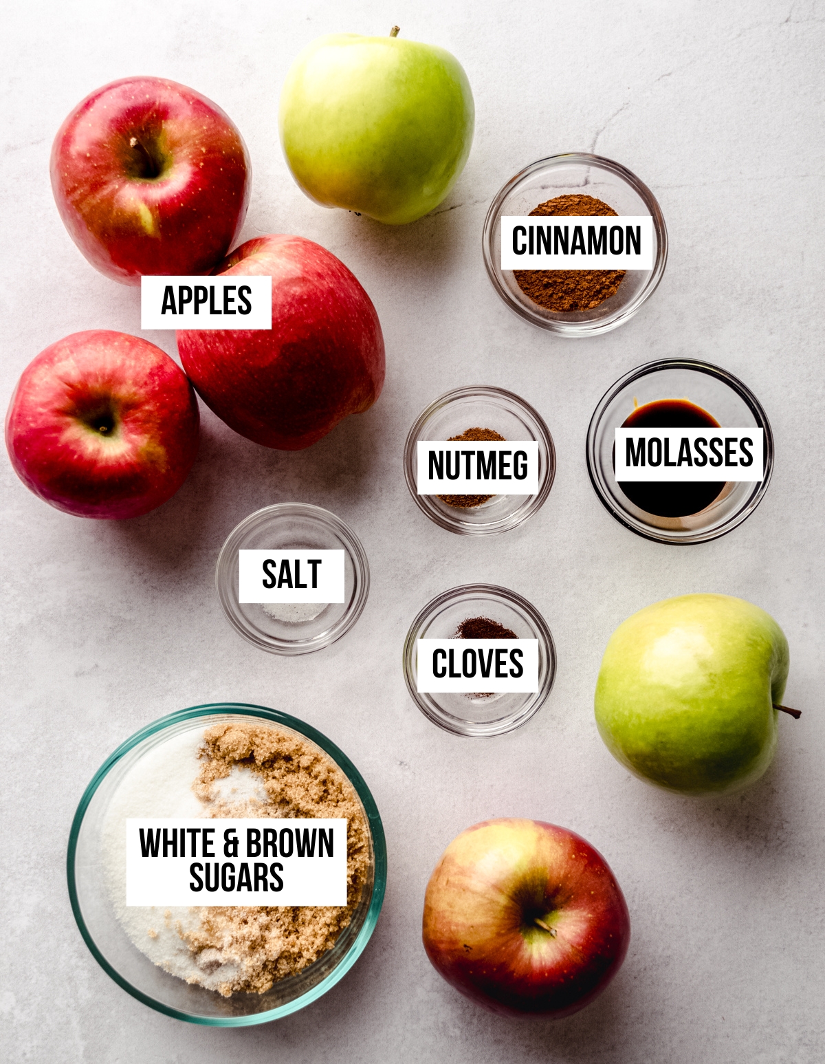 Aerial photo of ingredients to make apple butter with text overlay labeling each ingredient.