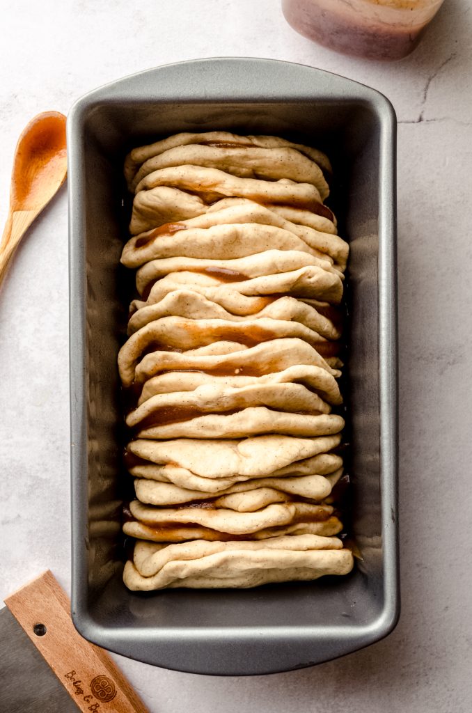 Aerial photo of apple butter pull-apart bread in a pan before it has risen.