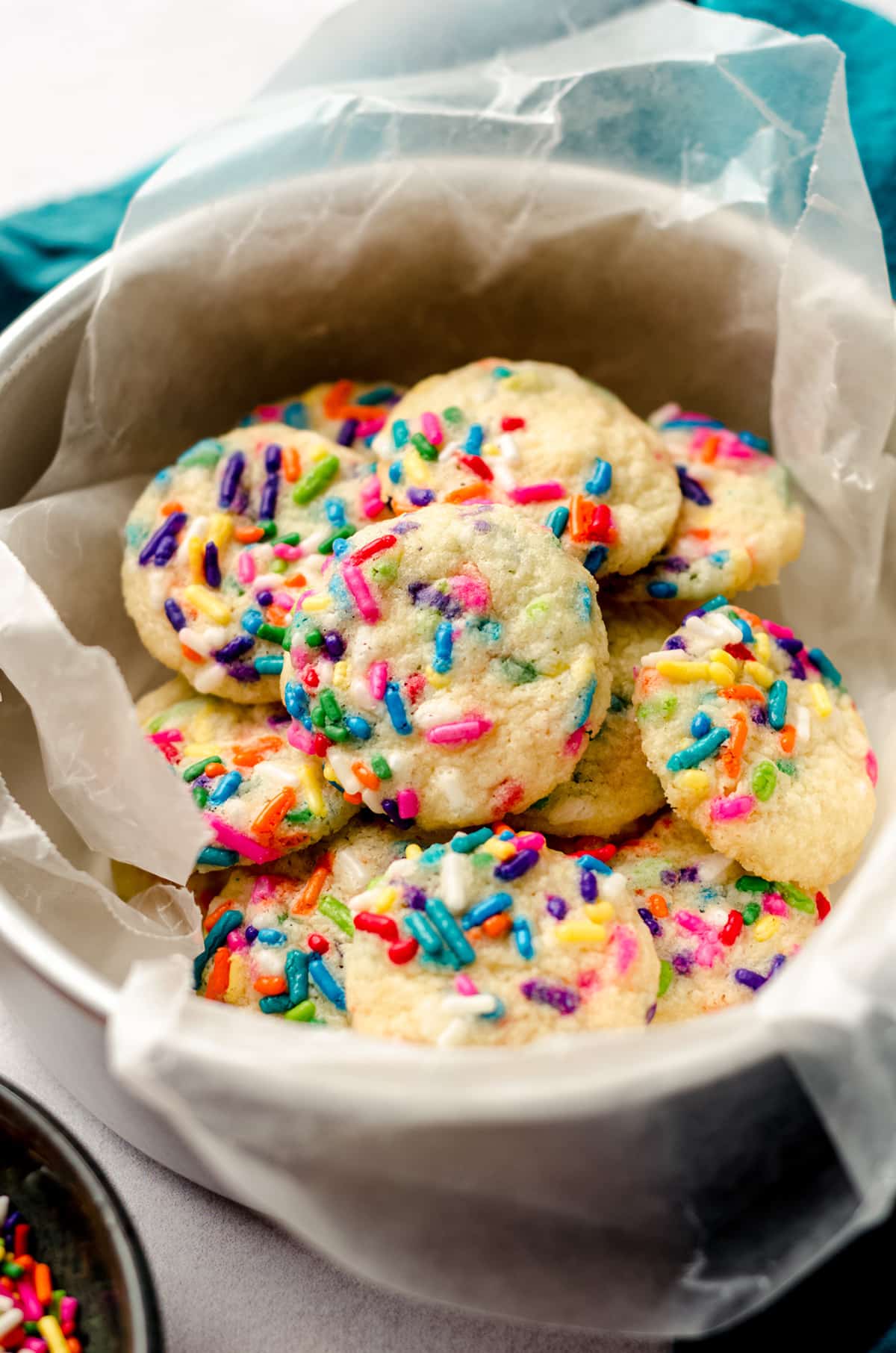 mini drop sugar cookies with sprinkles in a cookie tin