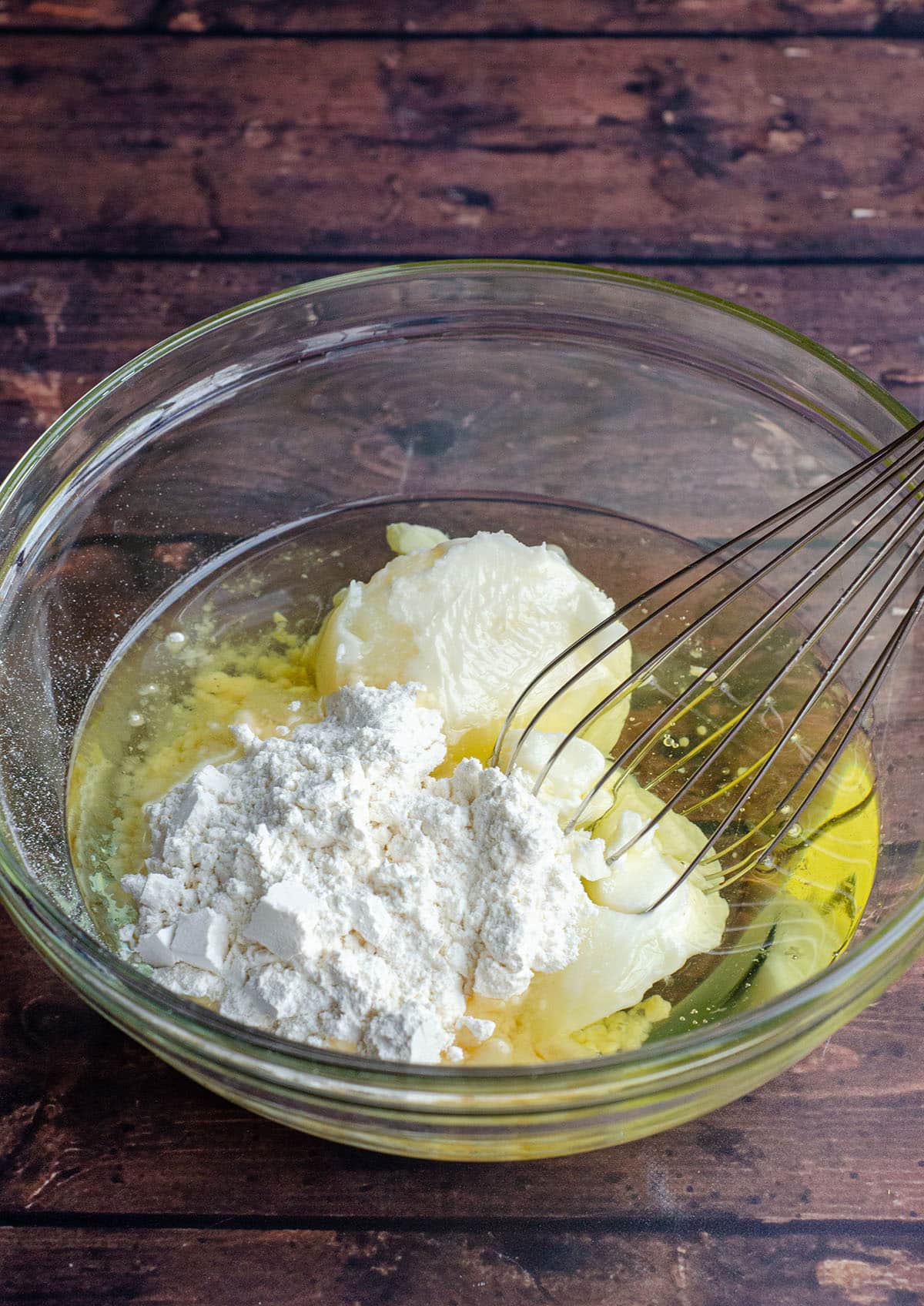 Ingredients for homemade cake release in a glass bowl with a whisk.