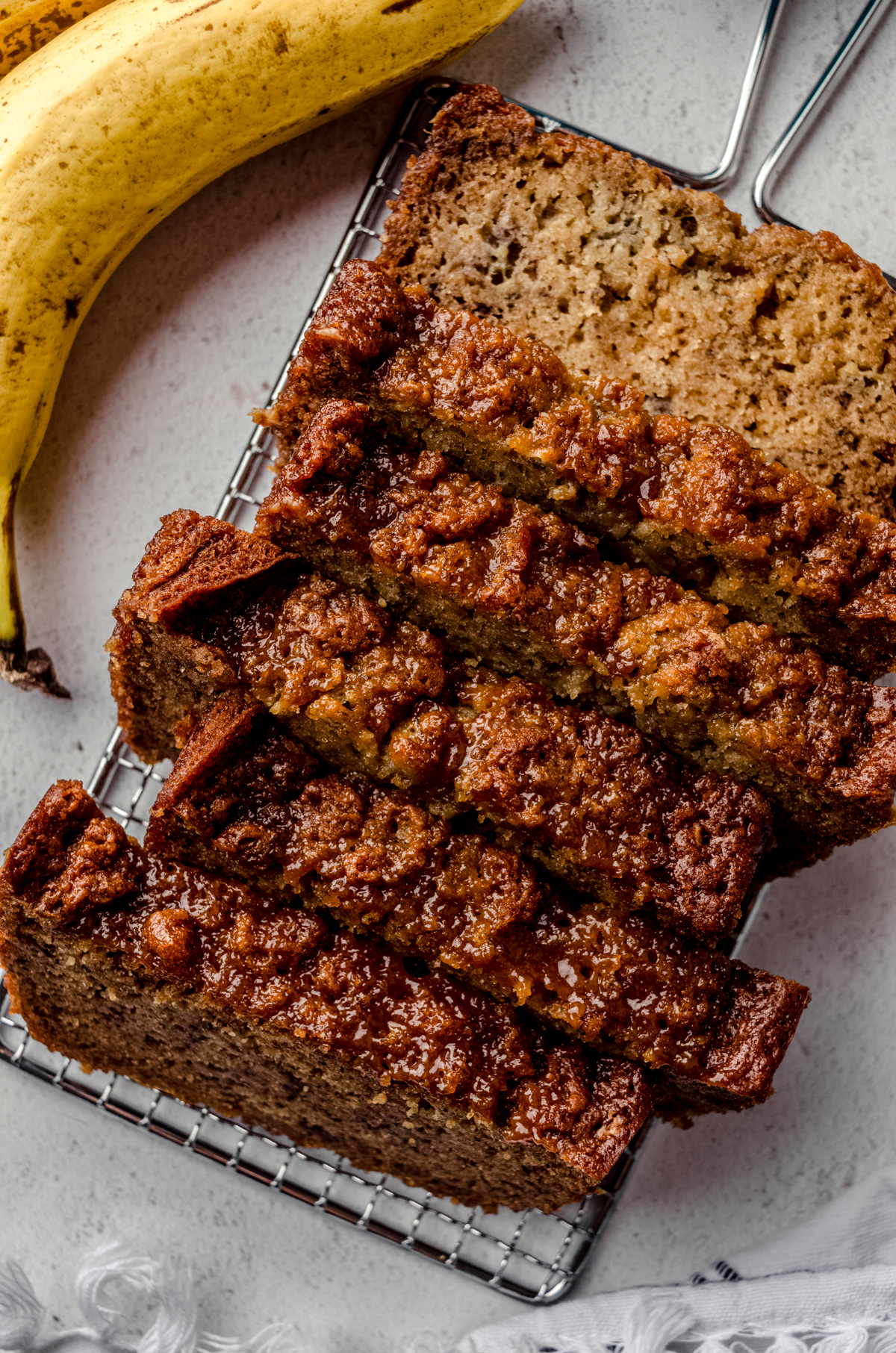 Slices of salted caramel banana bread on a cooling rack.