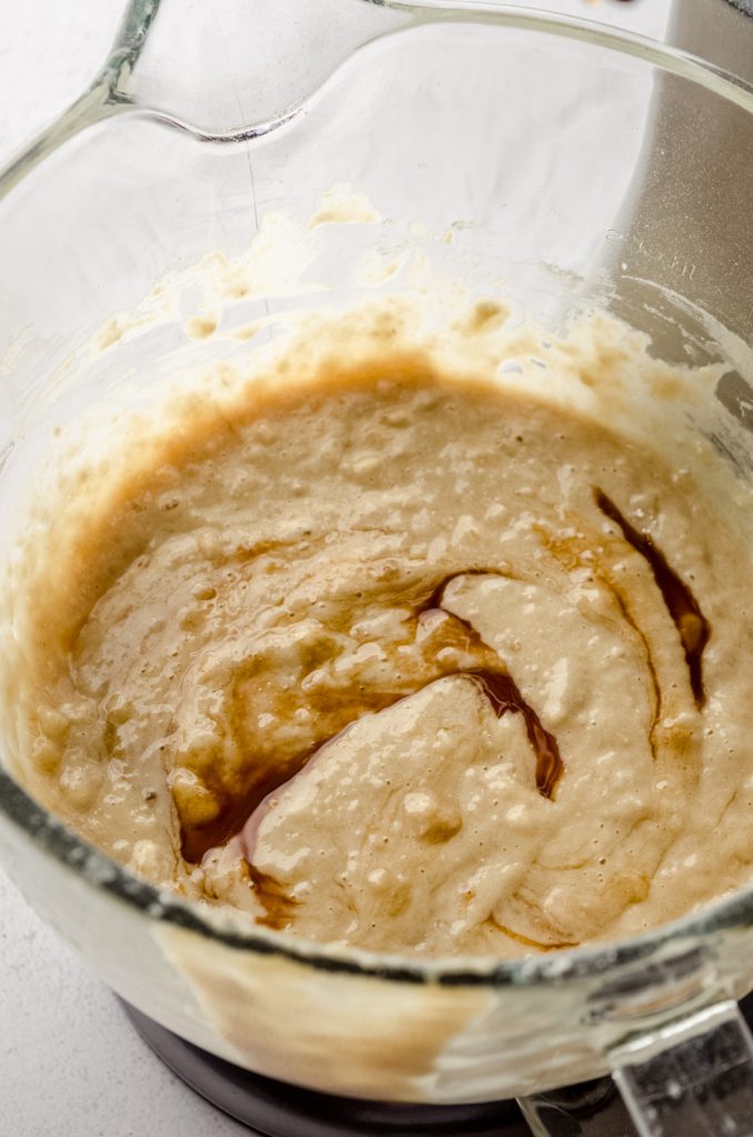 Salted caramel sauce swirled into banana bread batter in a bowl.