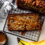 Aerial photo of a slice of salted caramel banana bread on a cooling rack.