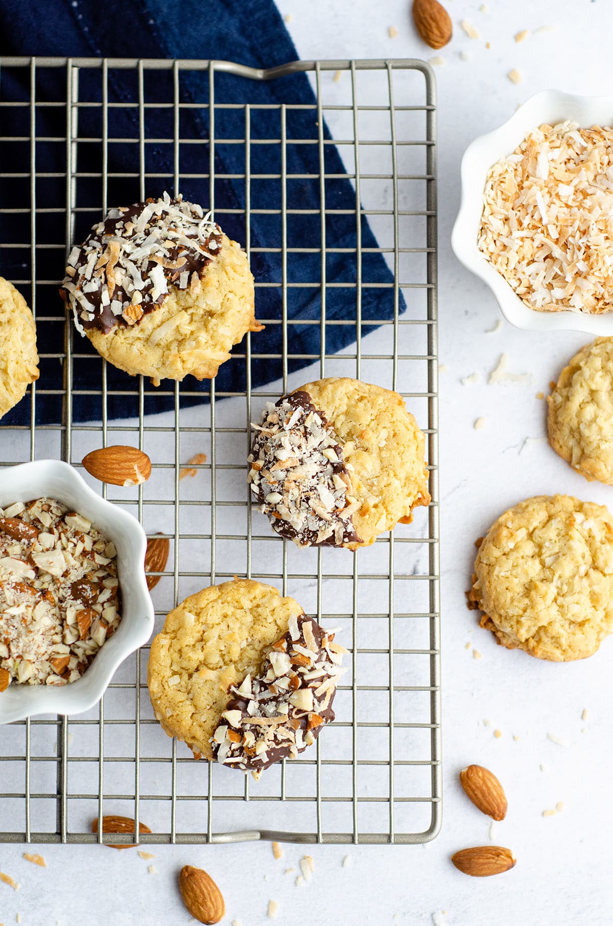 Easy coconut drop cookies, dipped in chocolate and sprinkled with toasted coconut and chopped almonds. via @frshaprilflours