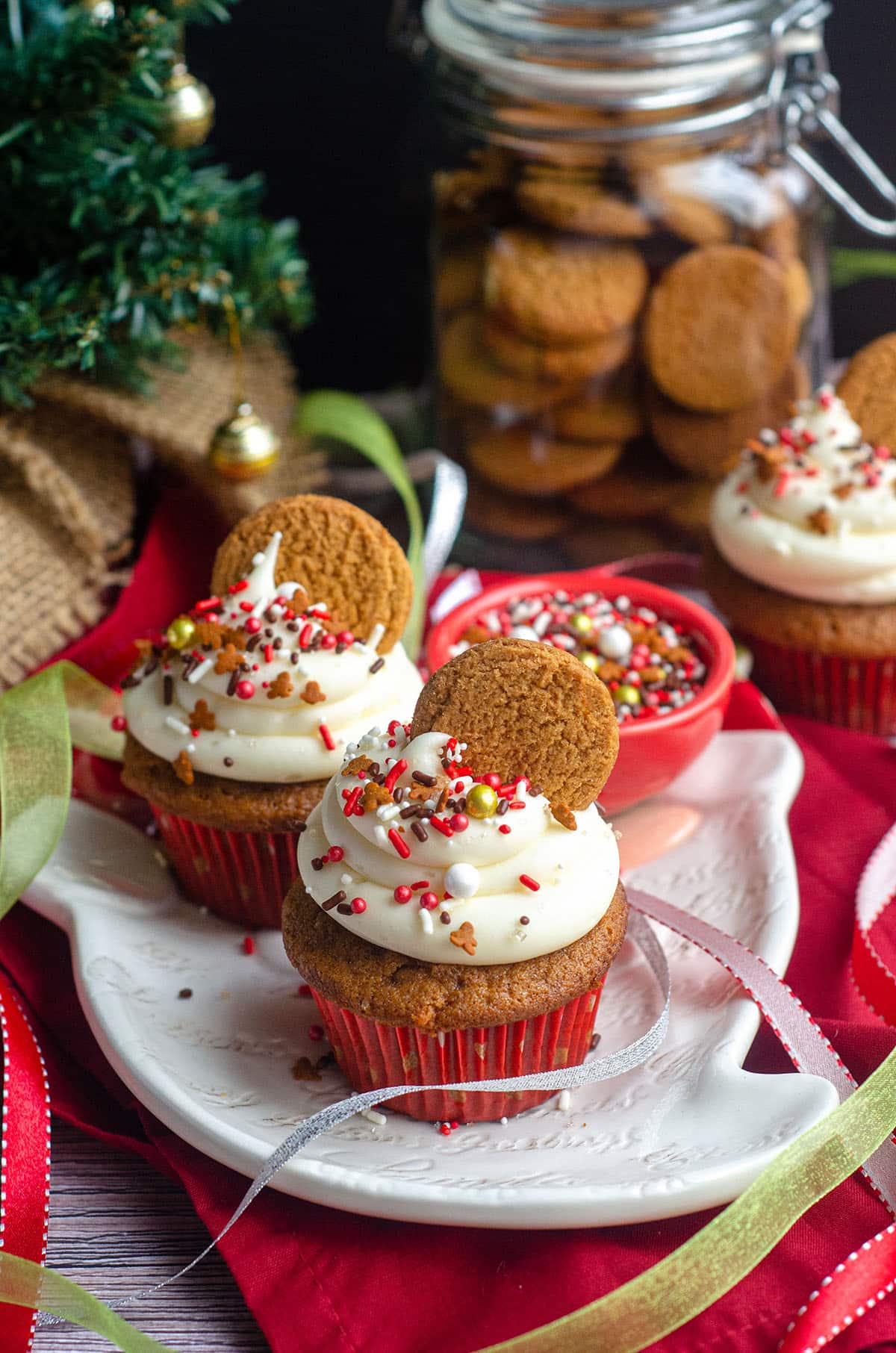 gingerbread cupcakes on a plate with christmas decor around it
