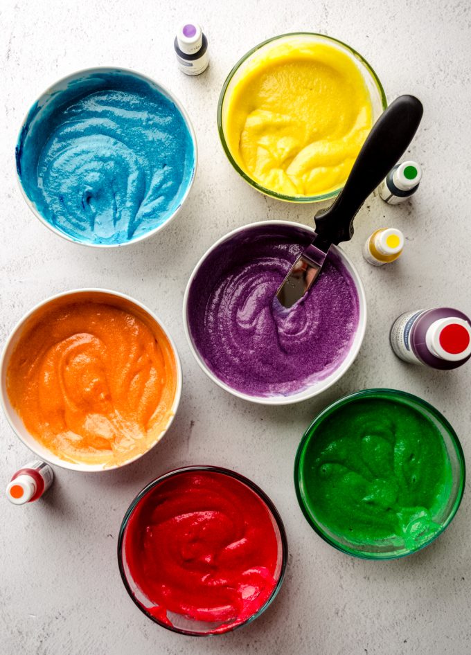 Aerial photo of bowls of batter tinted to make a rainbow cake.