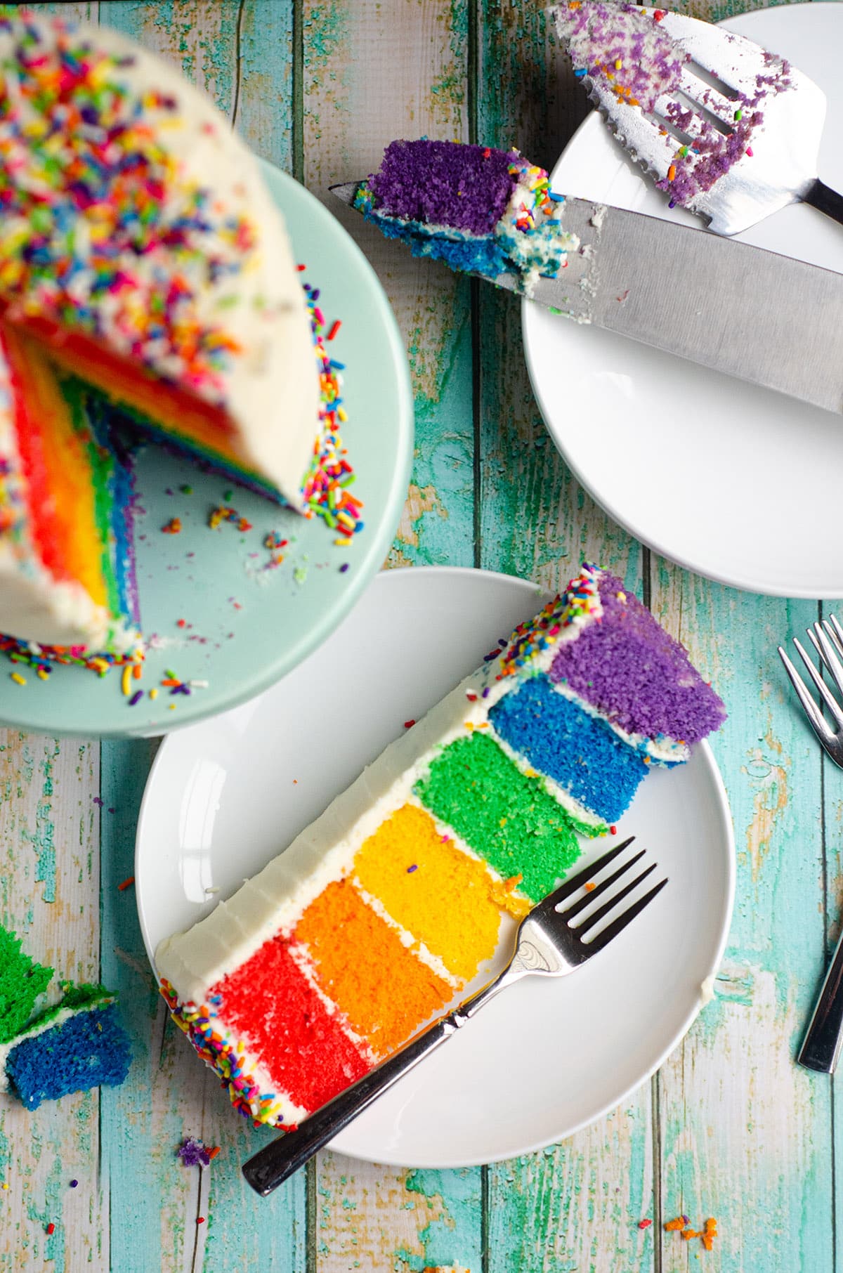 an aerial photo of a slice of rainbow cake on a plate