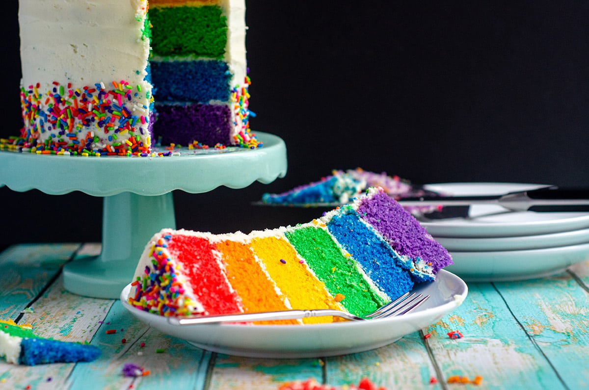 a slice of rainbow cake on a plate