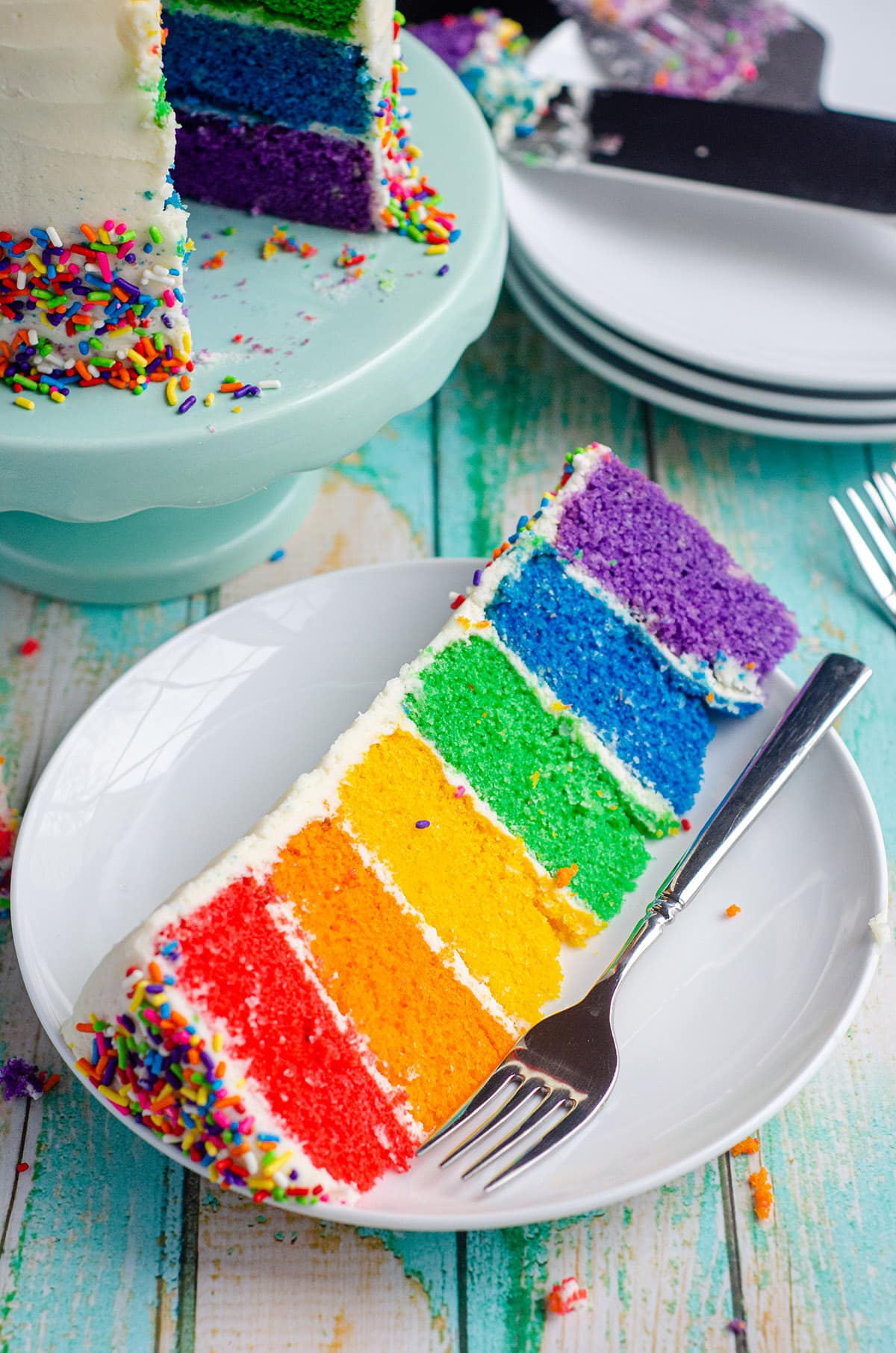 a slice of rainbow cake on a plate