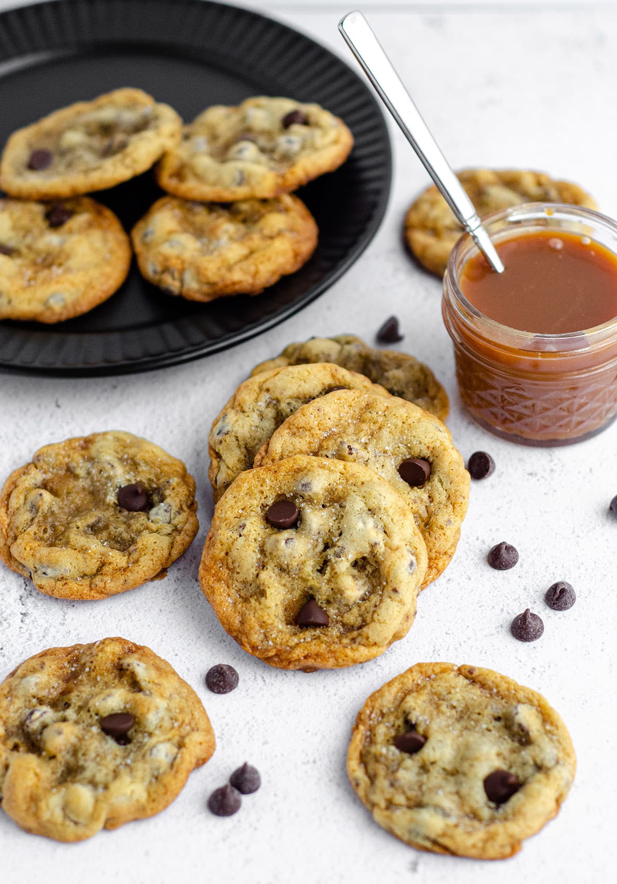 salted caramel chocolate chip cookies with a jar of salted caramel sauce