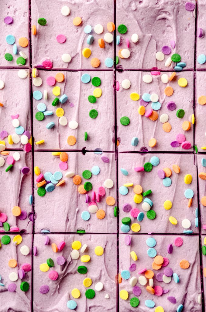 Aerial photo of frosted sugar cookie bars with sprinkles on top that have been sliced.