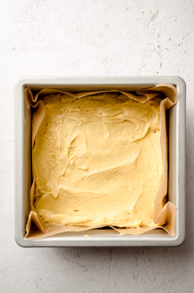 Aerial photo of sugar cookie bar dough pressed into a baking pan to make frosted sugar cookie bars.