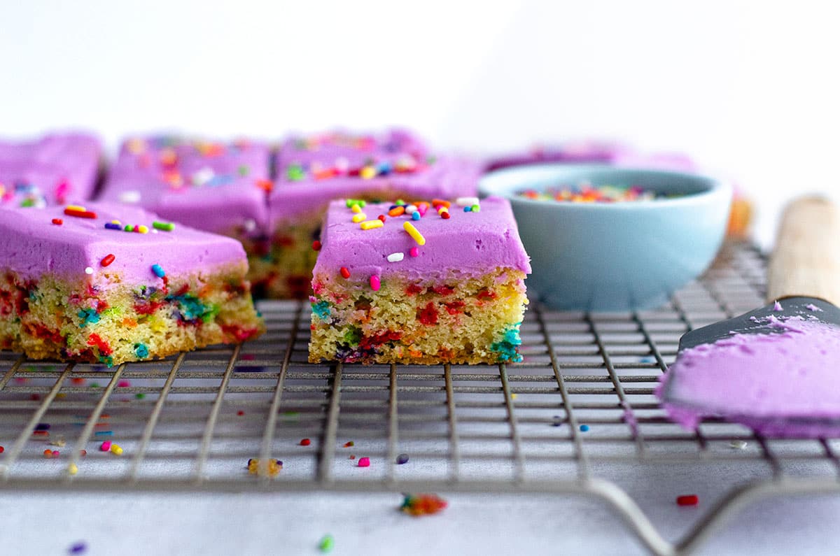 sugar cookie bars sliced and sitting on a cooling rack