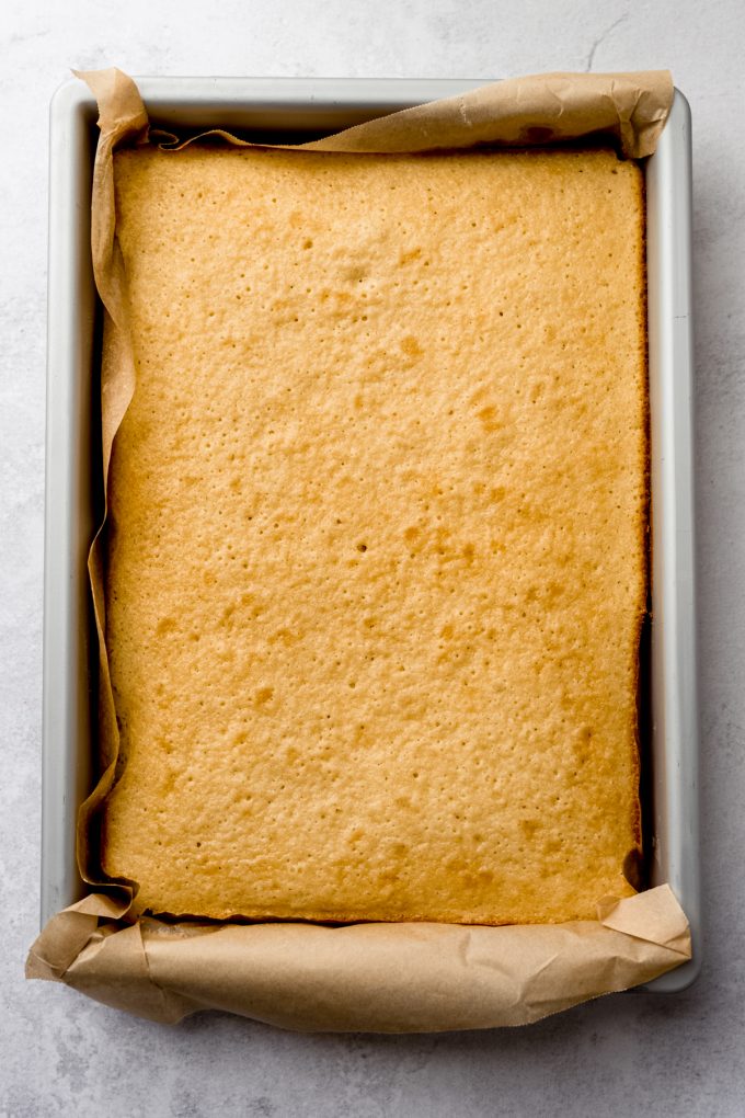 Aerial photo of a white sheet cake baked in a pan.