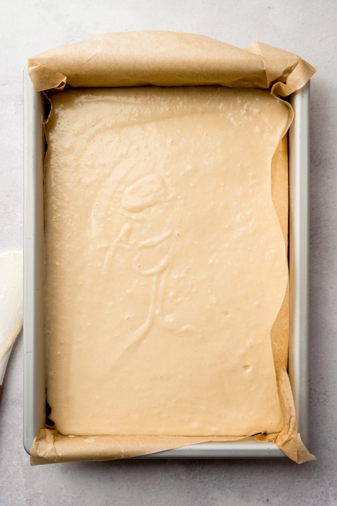 Aerial photo of a pan filled with white sheet cake batter.