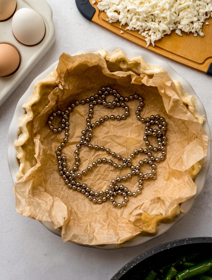 Aerial photo of a parbaked pie crust in a pie plate.