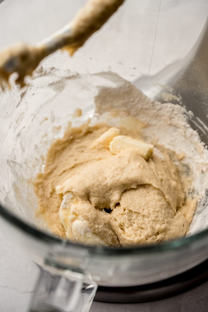 The bowl of a stand mixer with the start of yeast dough in it.