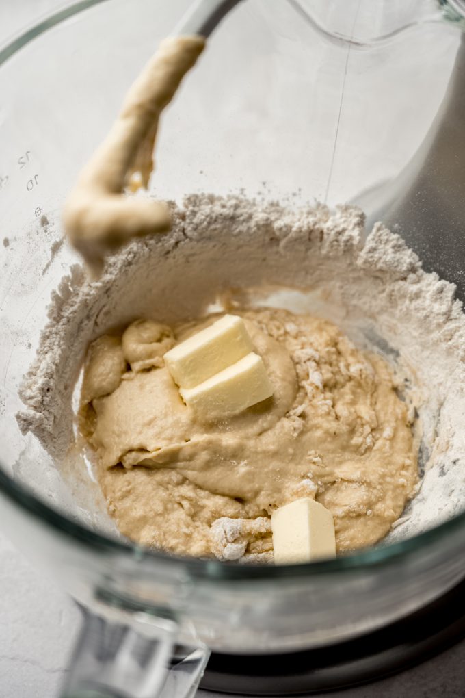 The bowl of a stand mixer with the start of yeast dough in it.