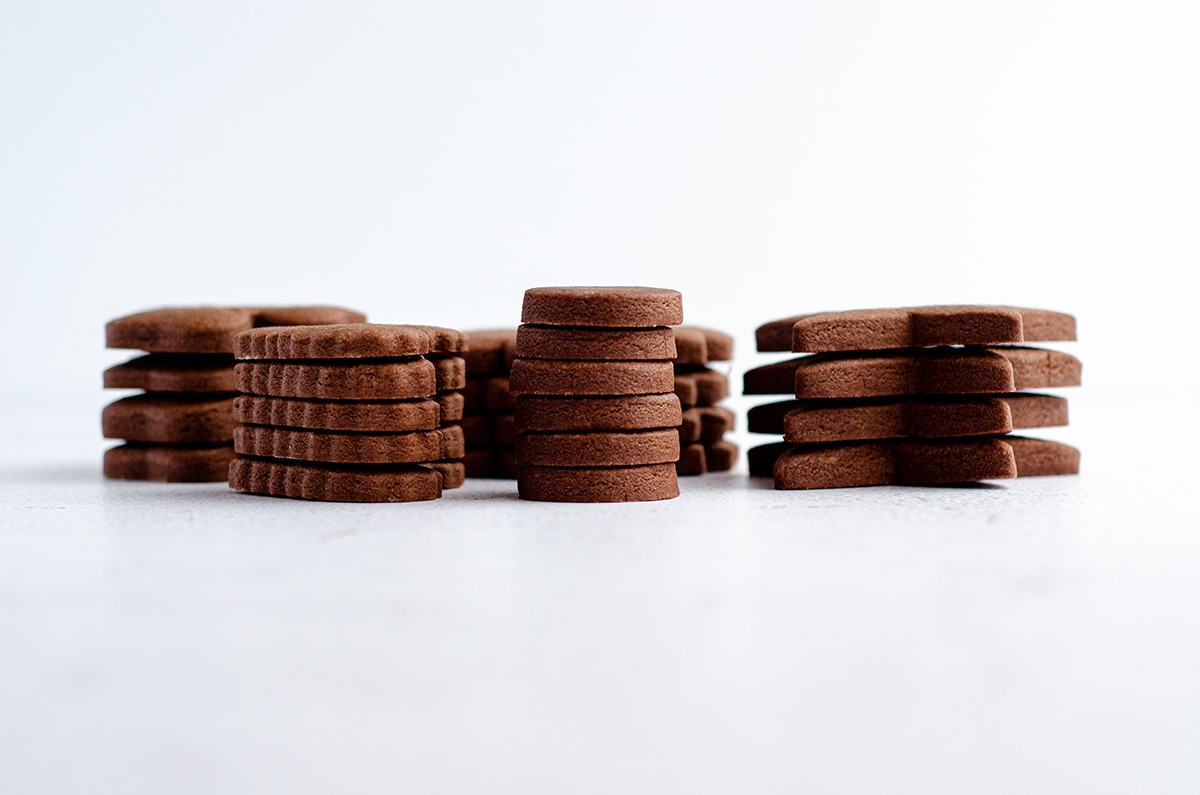 stacks of chocolate cut-out sugar cookies ready to decorate