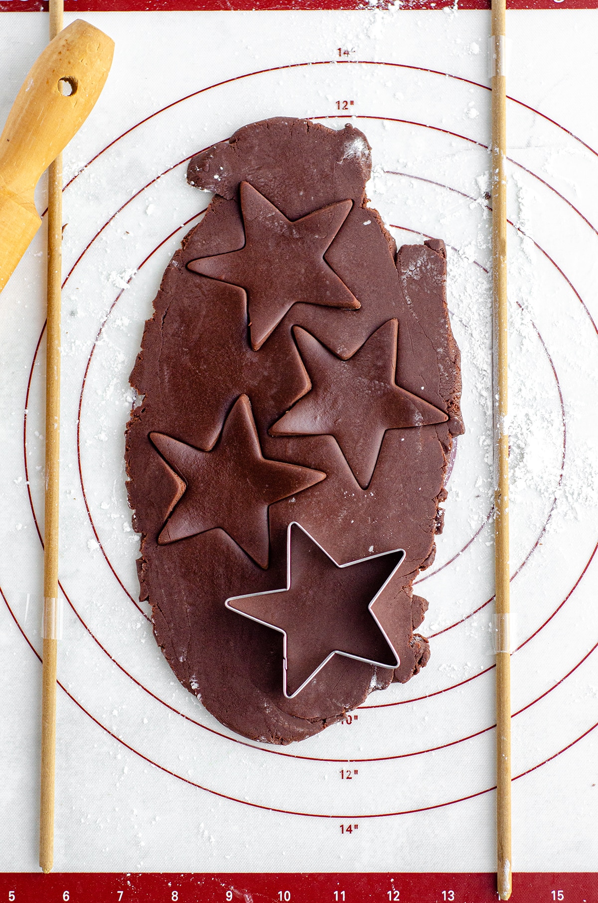 aerial photo of chocolate cut-out sugar cookie dough being cut into star shapes