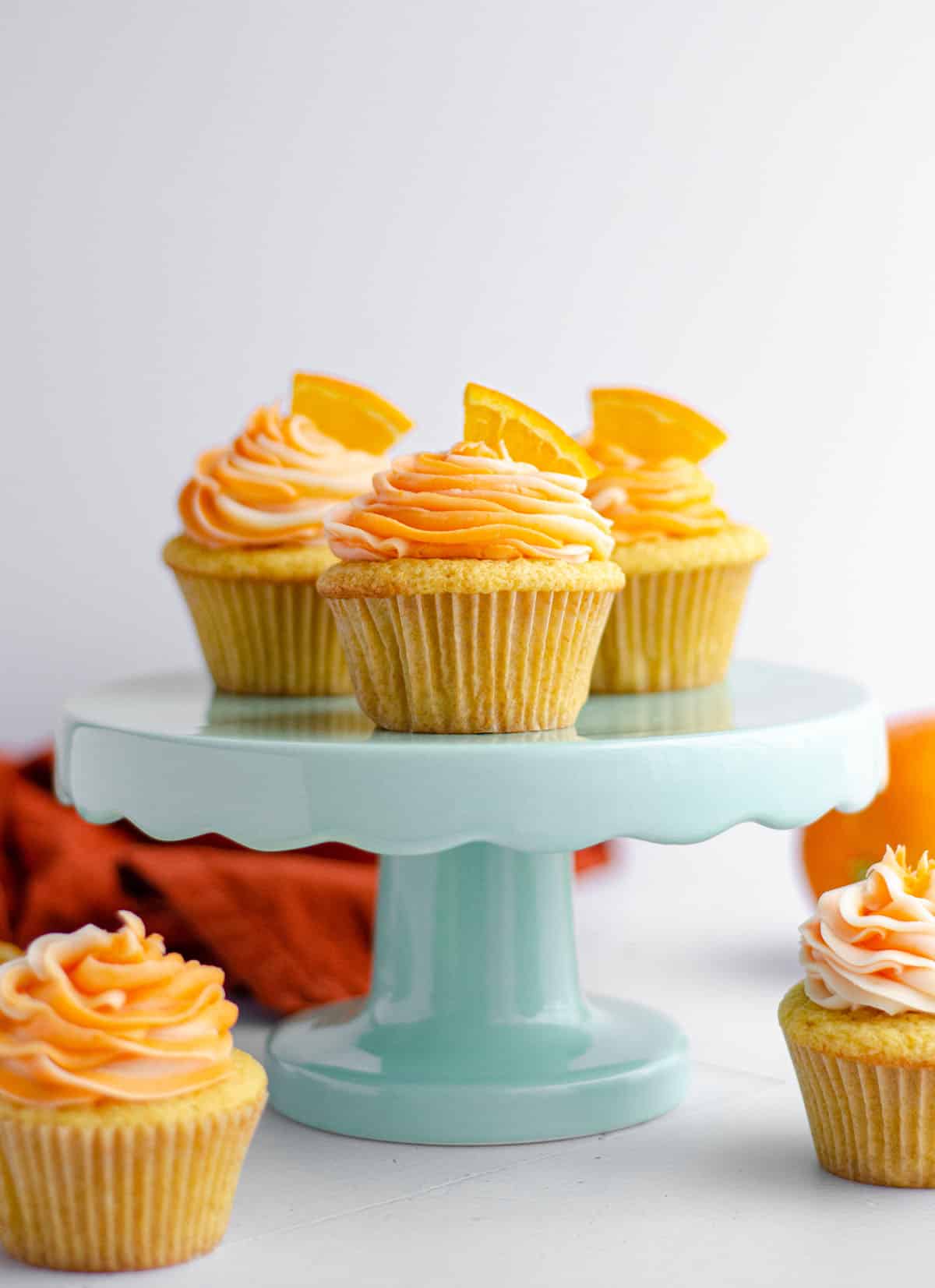 orange creamsicle cupcakes on a light blue cupcake stand