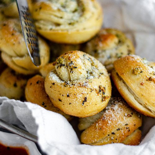Homemade Garlic Knots: Easy garlic knots made from store bought pizza dough. Crunchy and flavorful on the outside, soft and fluffy on the inside, and ready in less than 30 minutes.