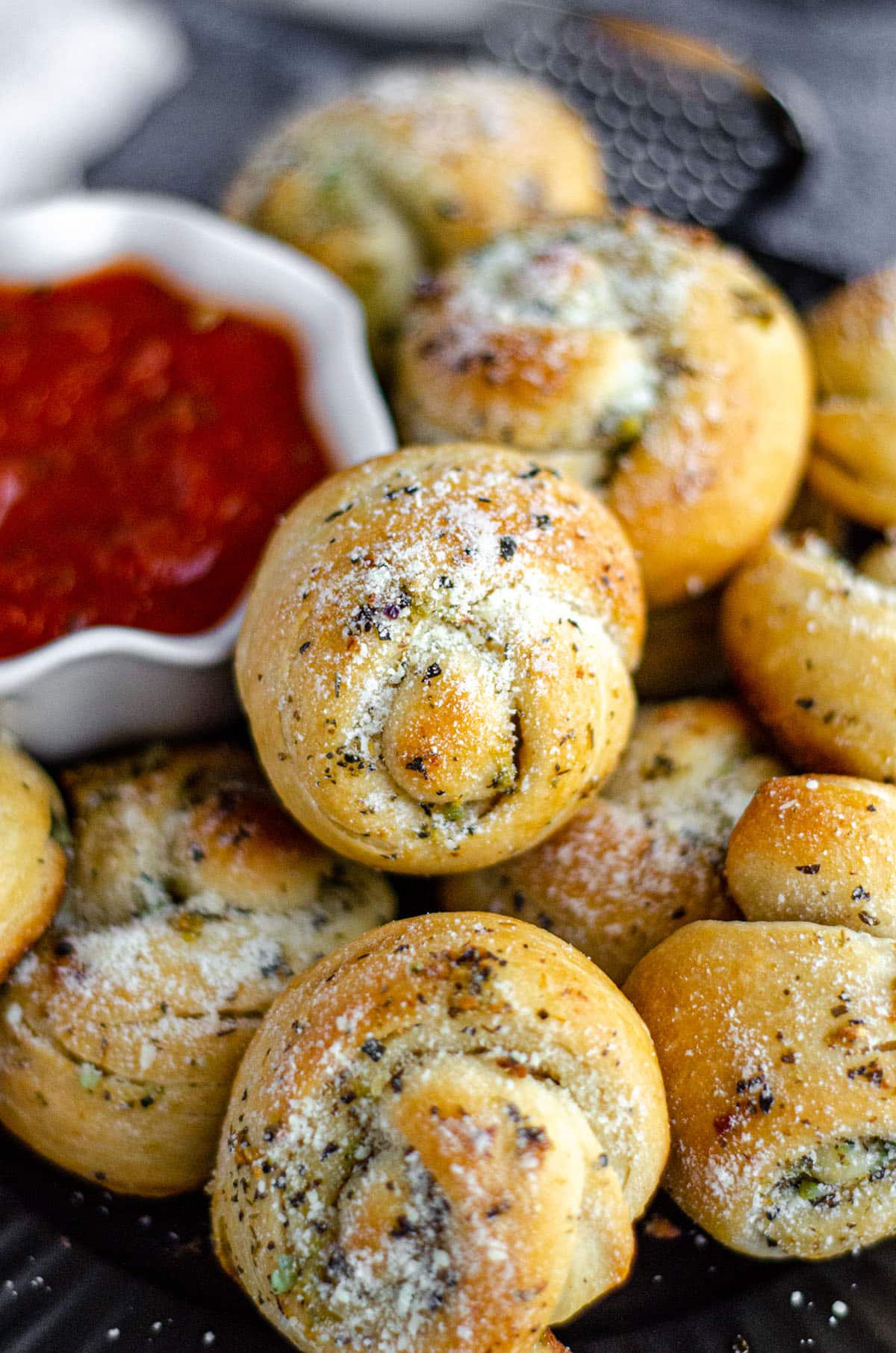 homemade garlic knots with a bowl of marinara