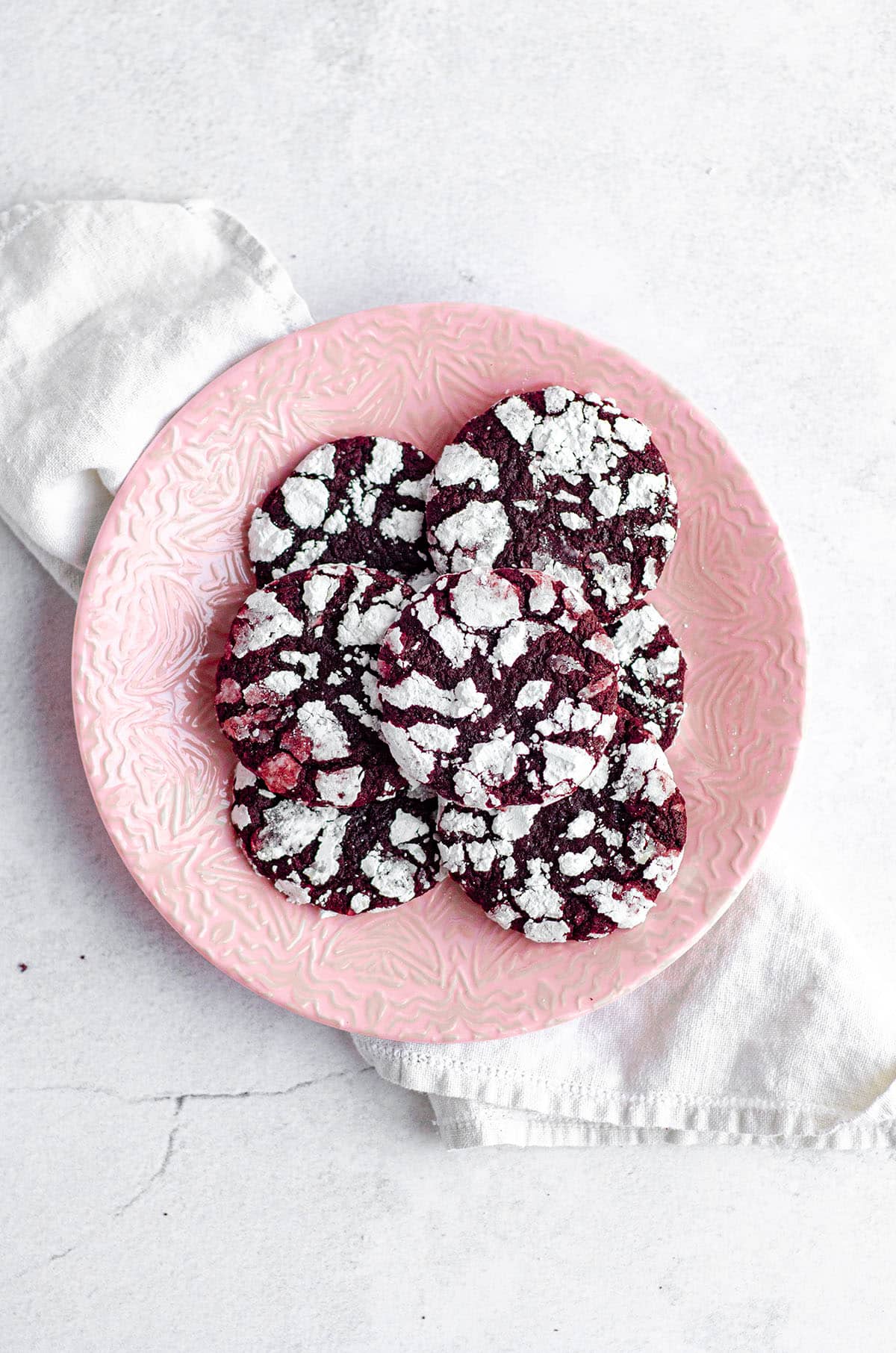 red velvet crinkle cookies on a pink plate