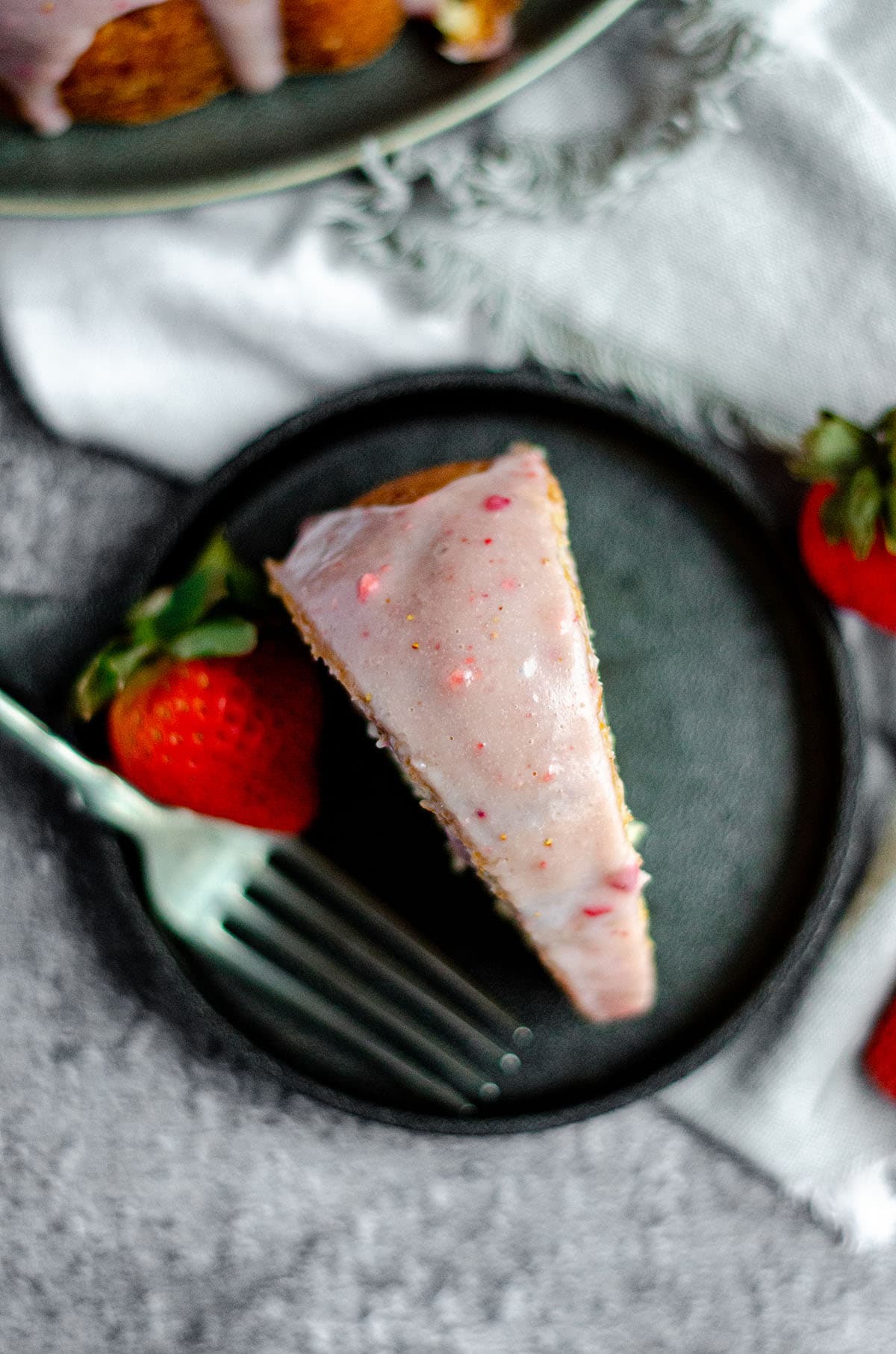 aerial photo of a slice of strawberry bundt cake on a plate with a fork