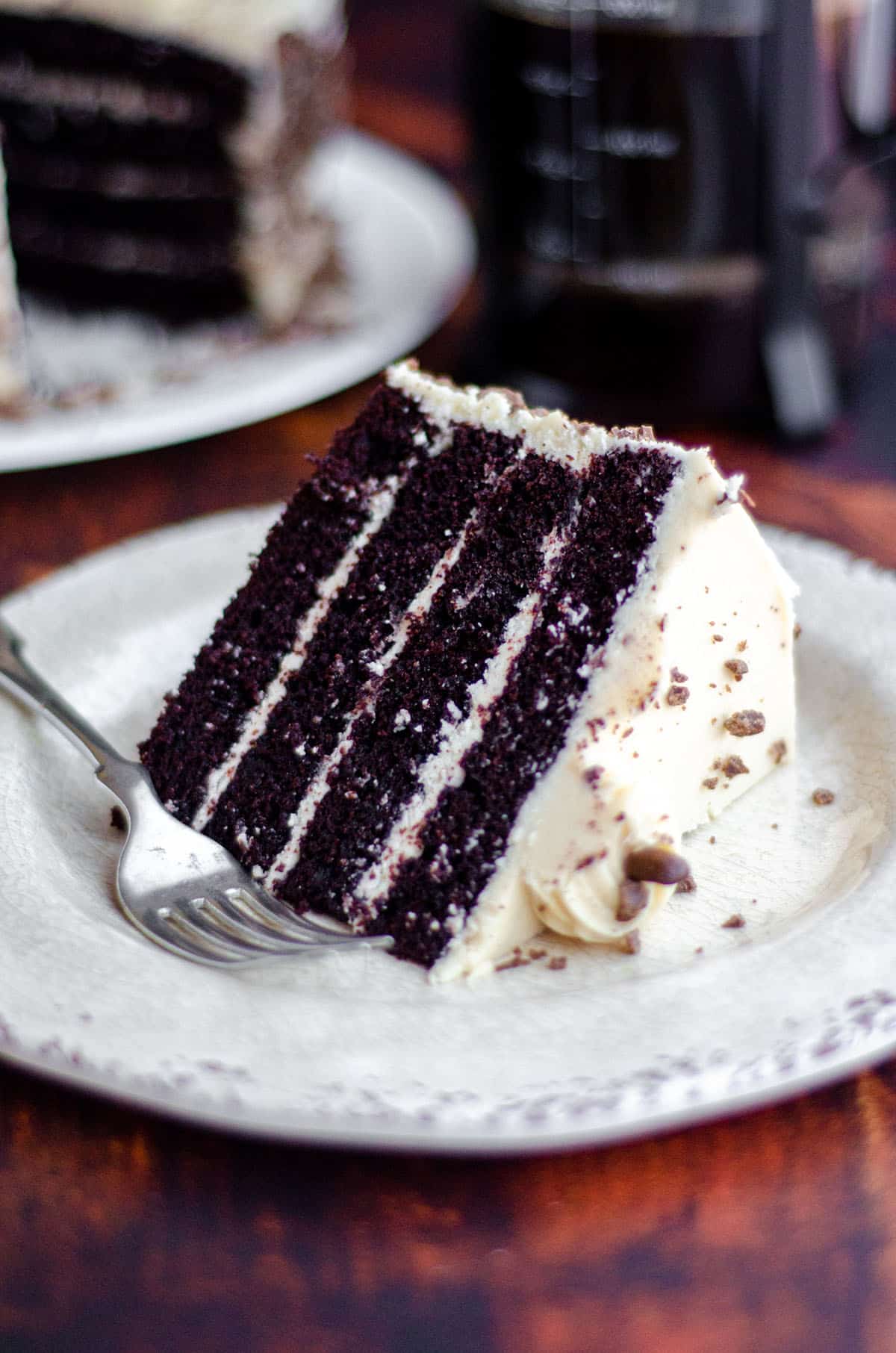 slice of mocha cake with coffee buttercream on a cream colored plate