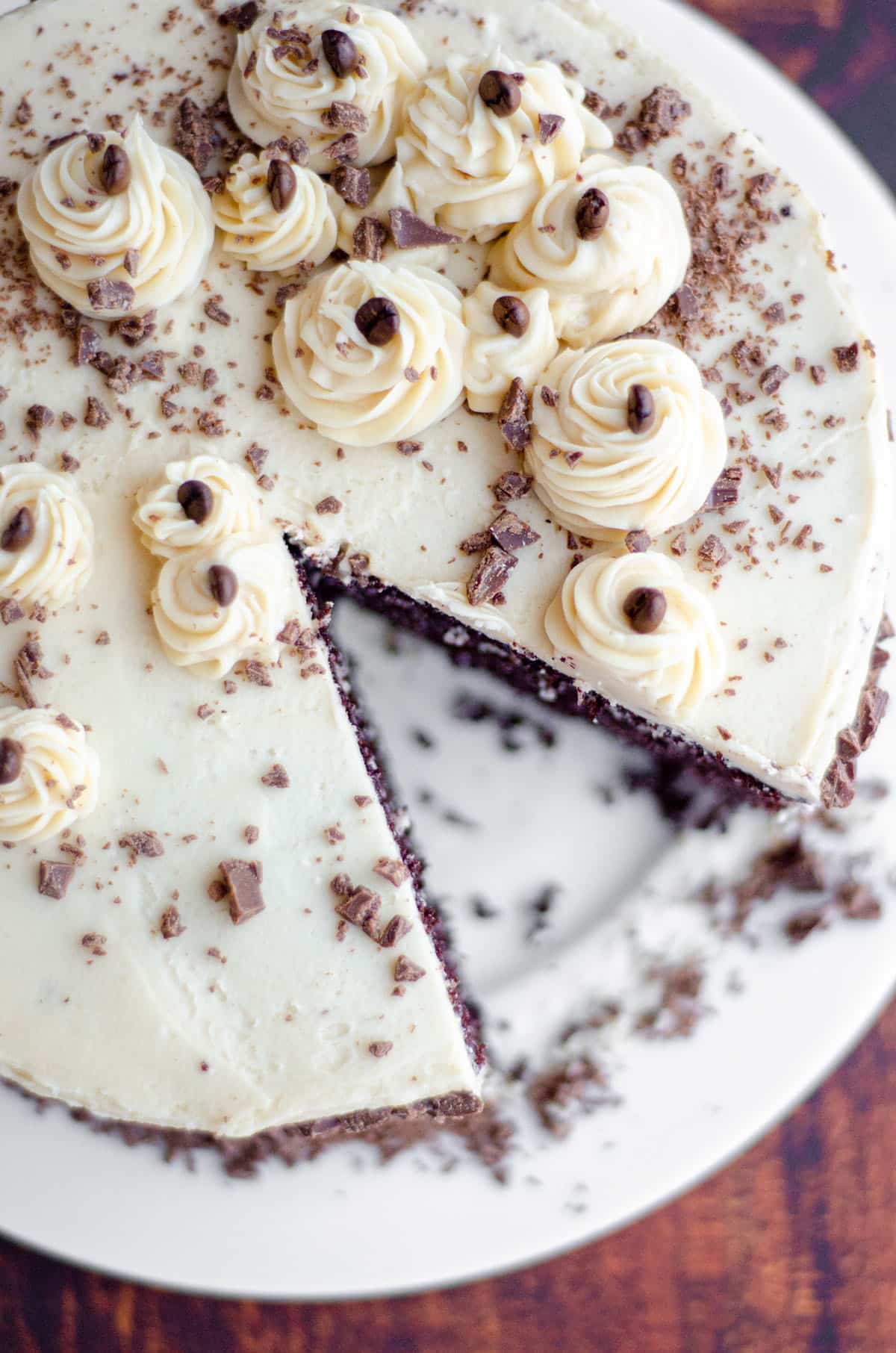 aerial photo of mocha cake with coffee buttercream on a plate with a slice taken out of it