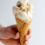 Praline Ice Cream: An easy homemade vanilla ice cream base swirled with salted caramel sauce and crunchy pecan praline pieces.