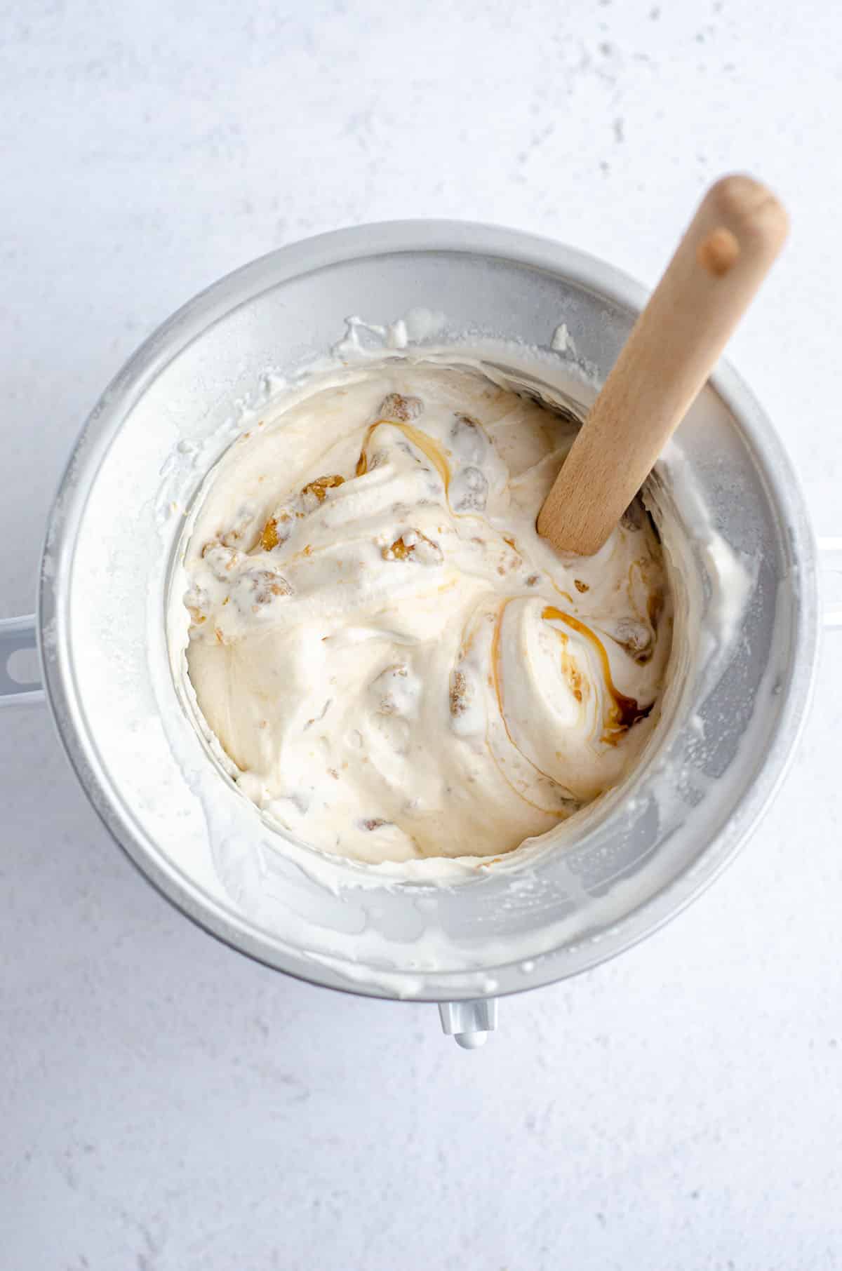 aerial photo of praline ice cream in an ice cream maker with a spatula sticking into it