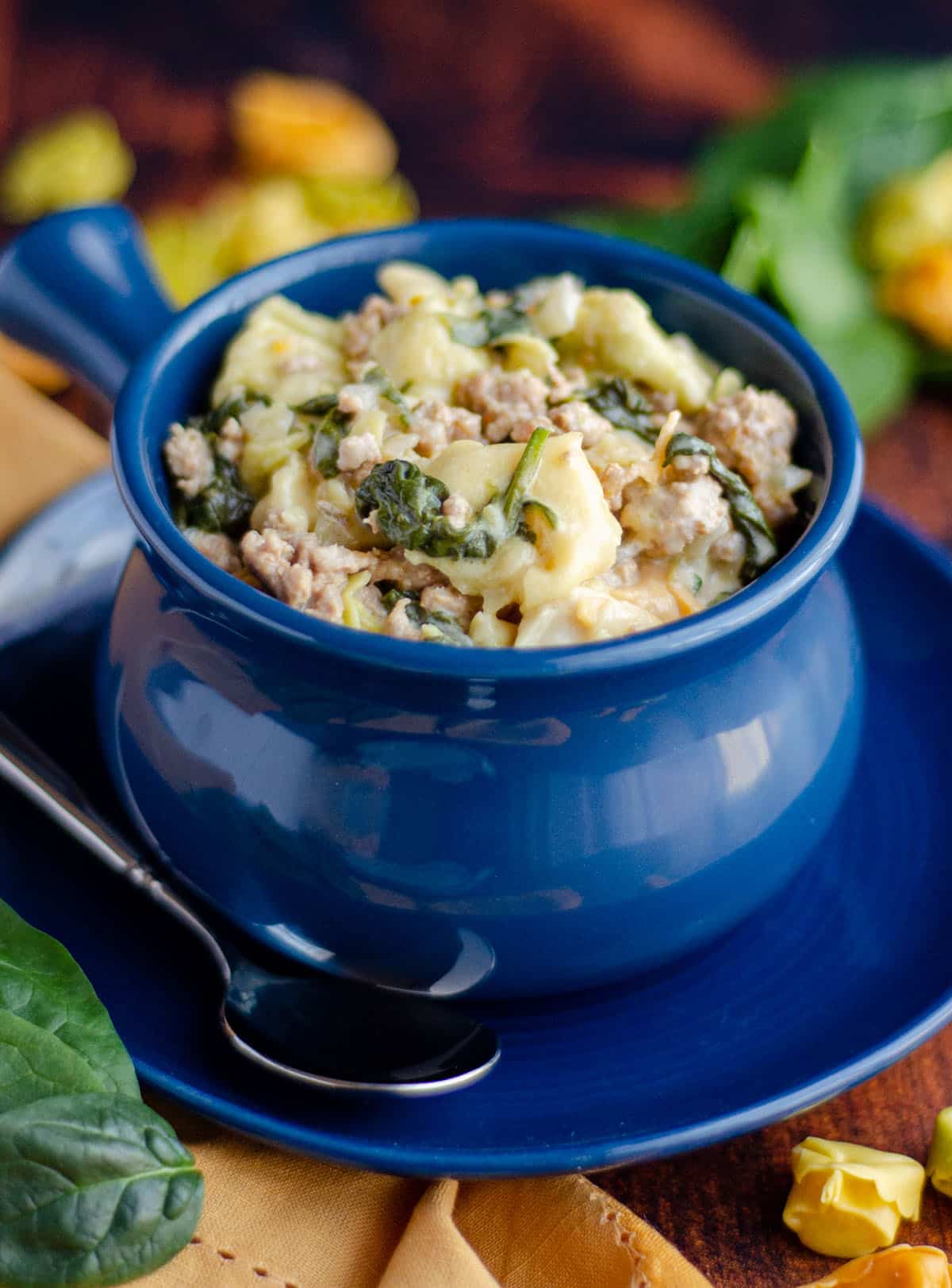 sausage tortellini soup in a blue bowl