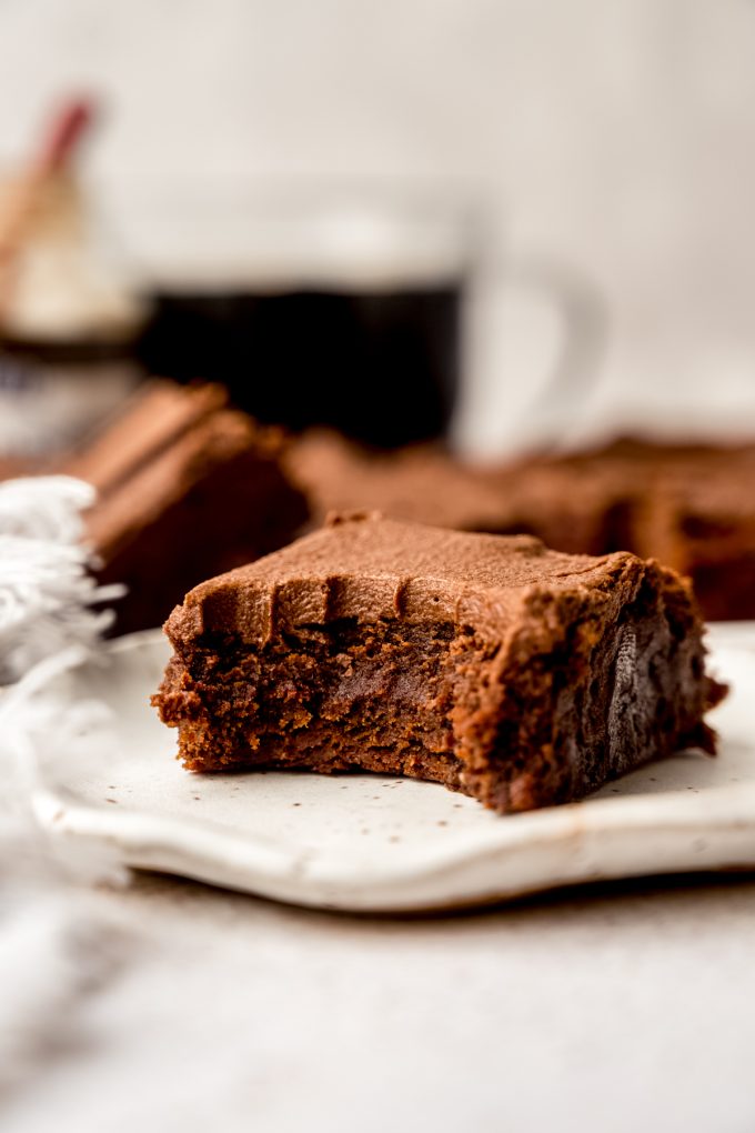 A coffee brownie on a plate with a bite taken out of it.