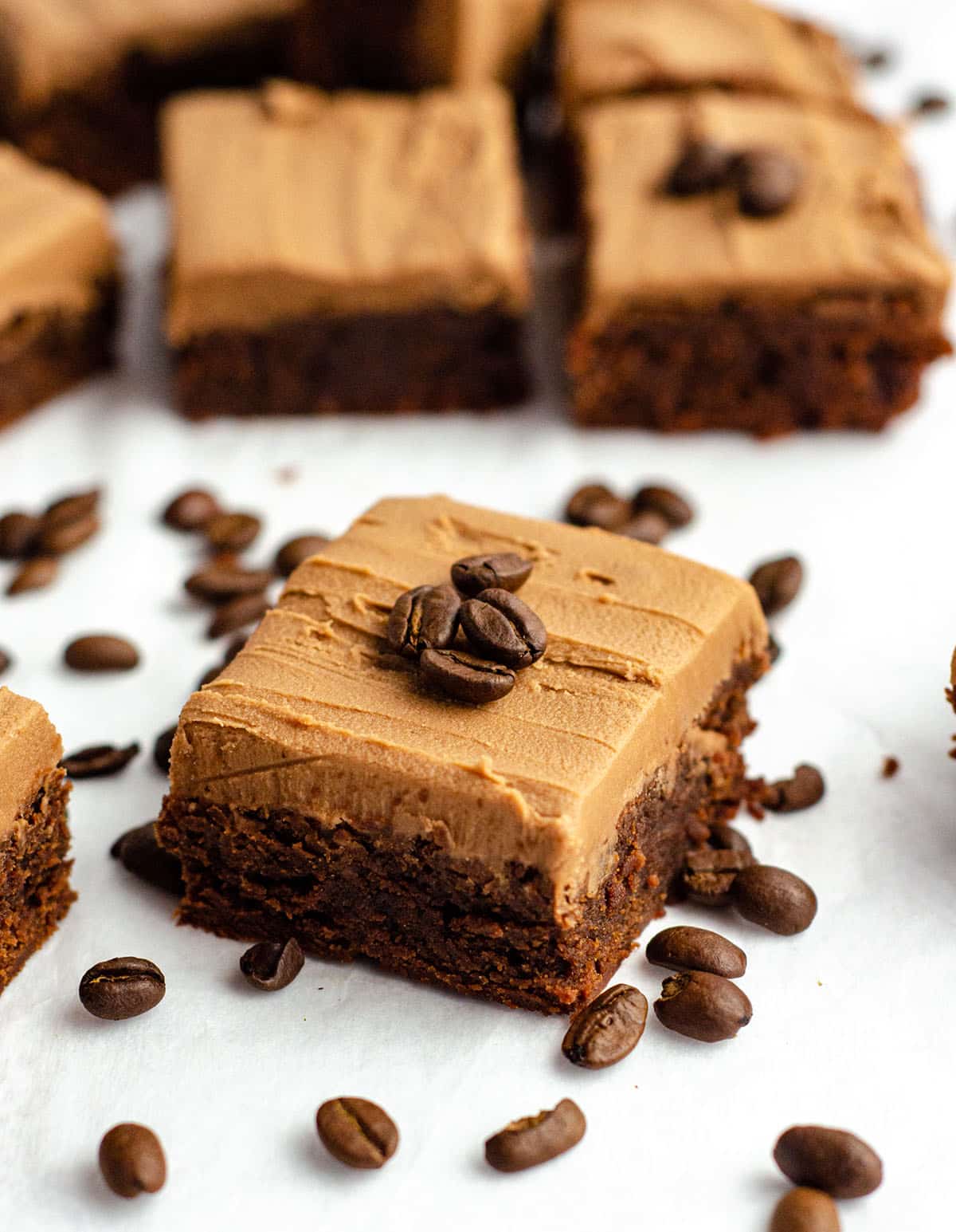 coffee brownie with mocha frosting and coffee beans on top of it for garnish