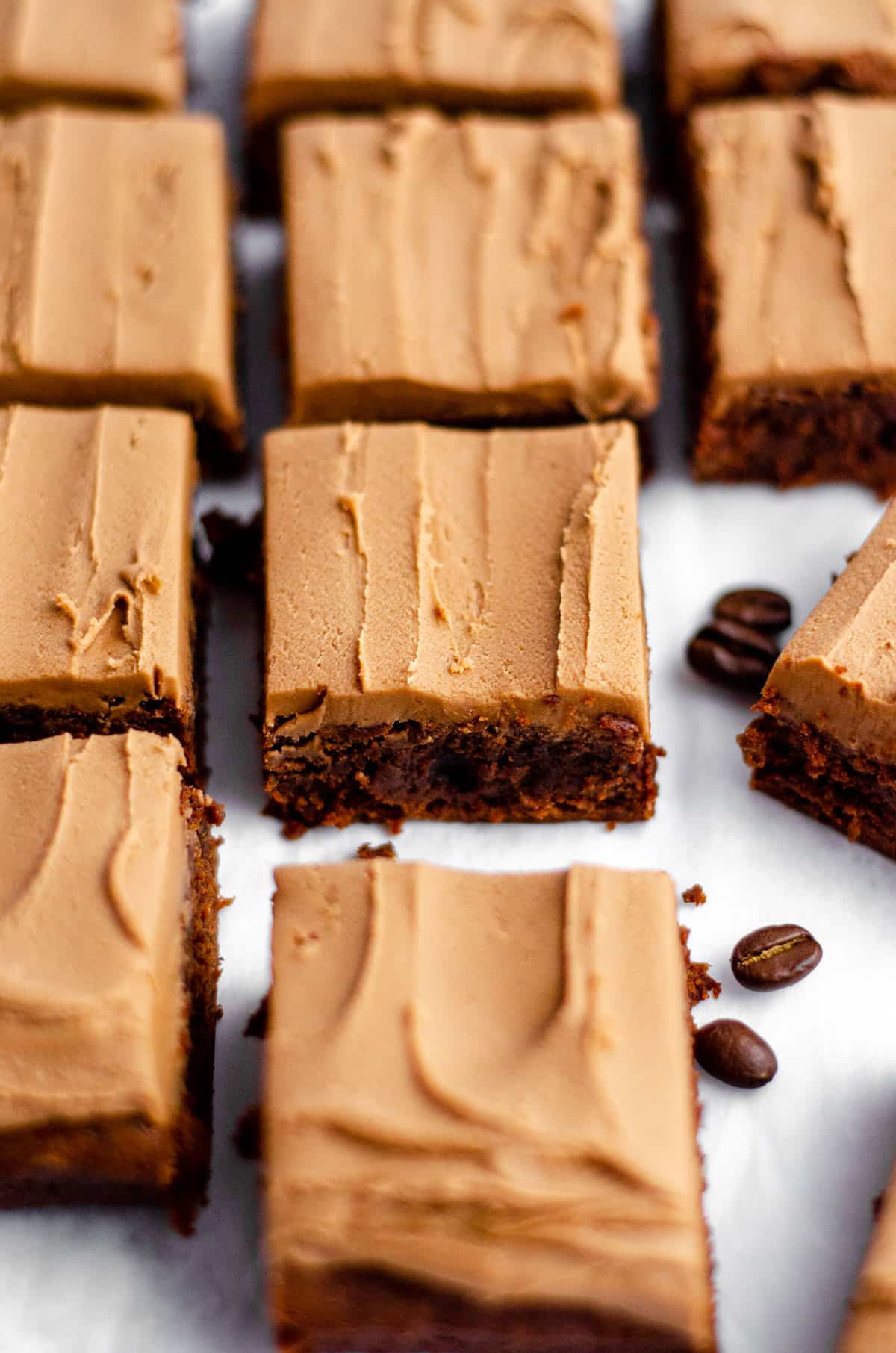 coffee brownies with mocha frosting sliced and on a white surface